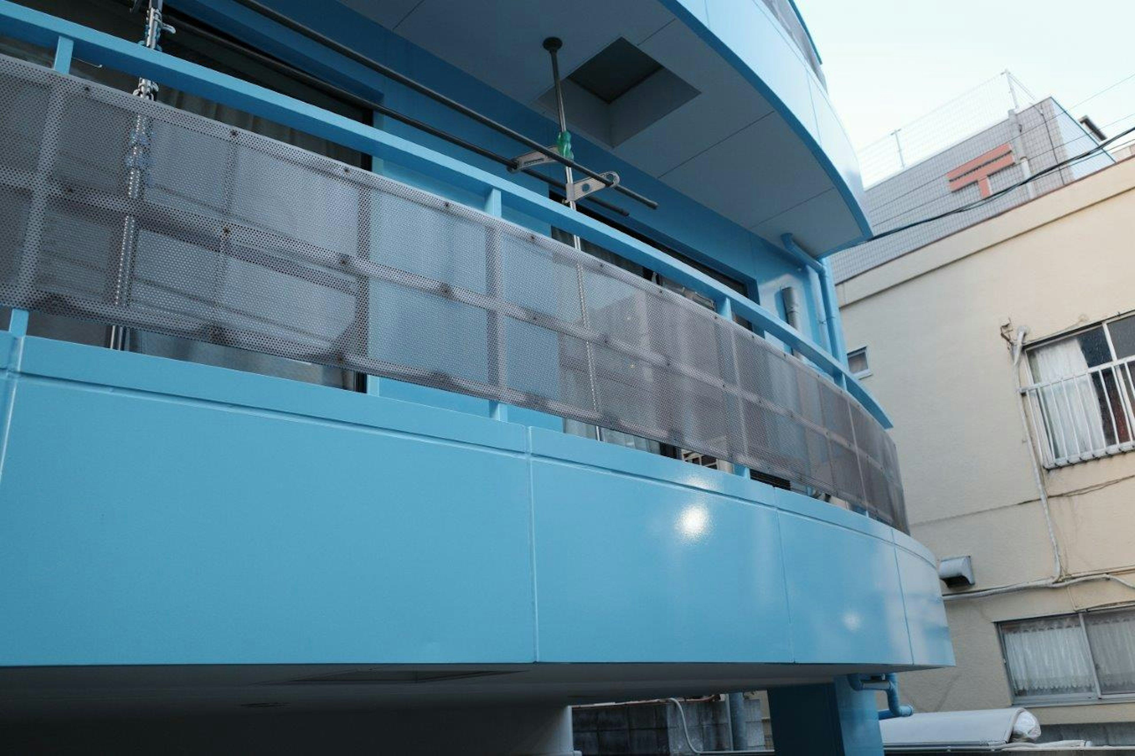 Vue extérieure d'un balcon de bâtiment bleu avec balustrade transparente