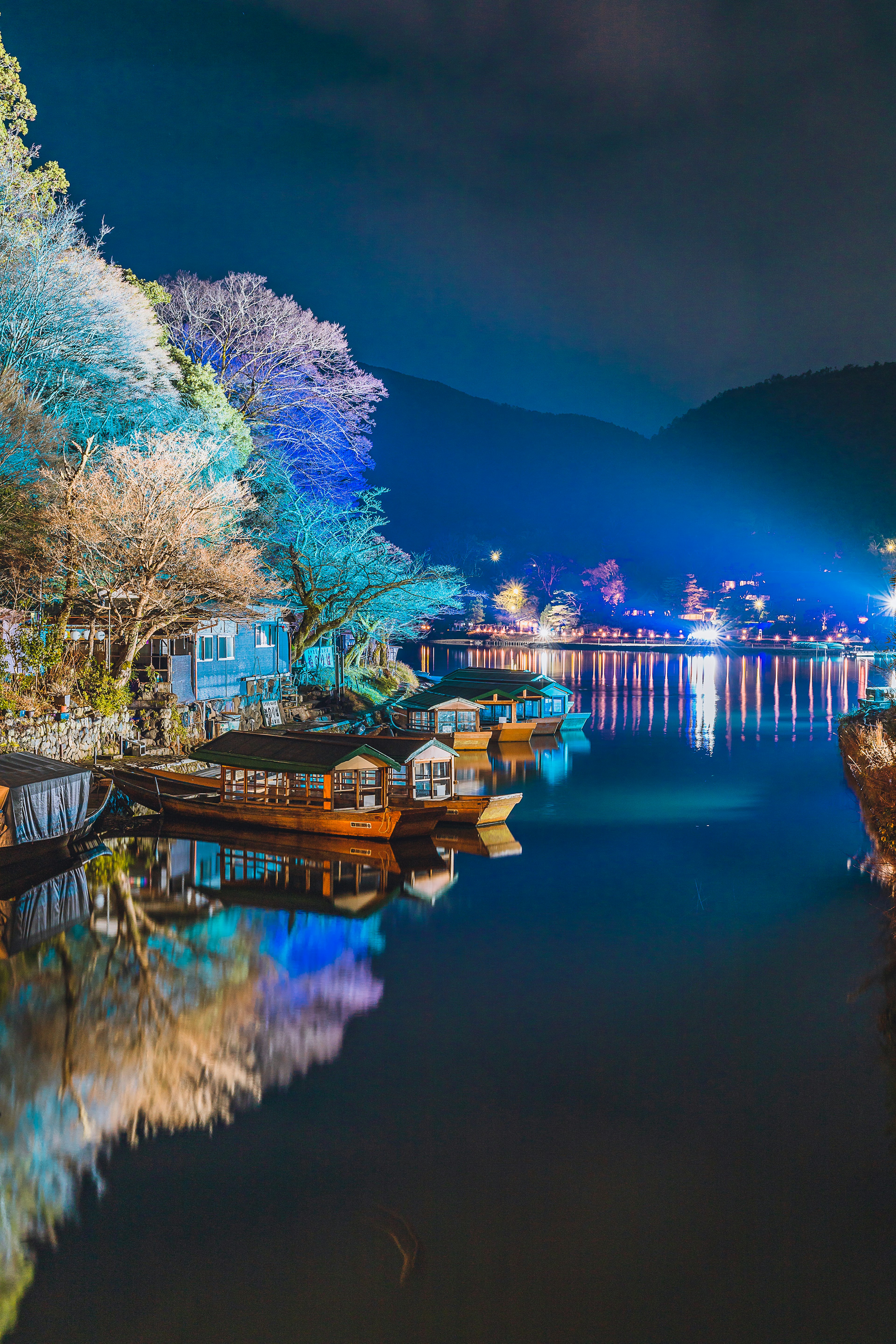 Lago notturno sereno con belle riflessioni di barche e alberi