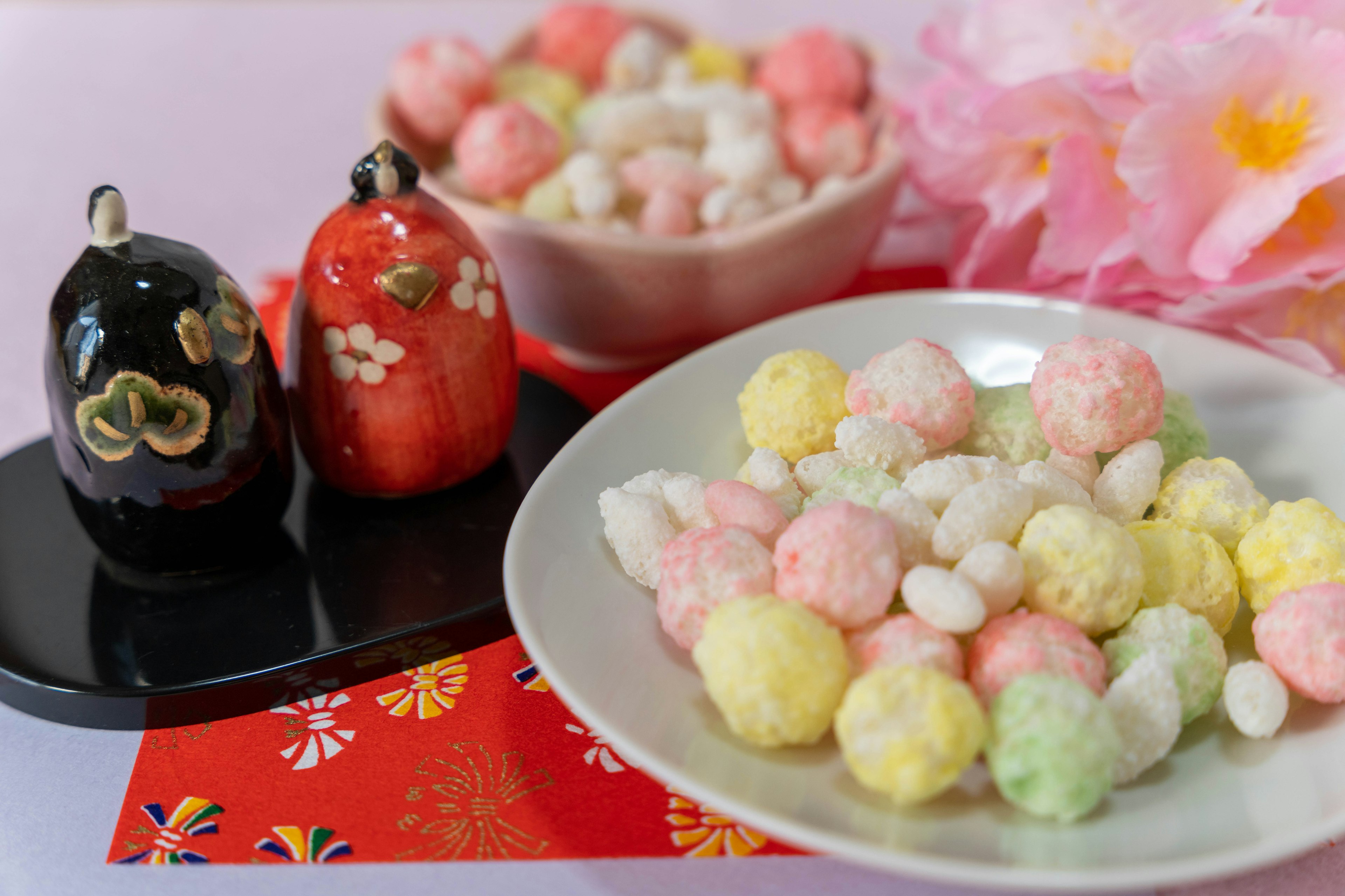 Dulces japoneses coloridos dispuestos con adornos tradicionales en un plato decorativo