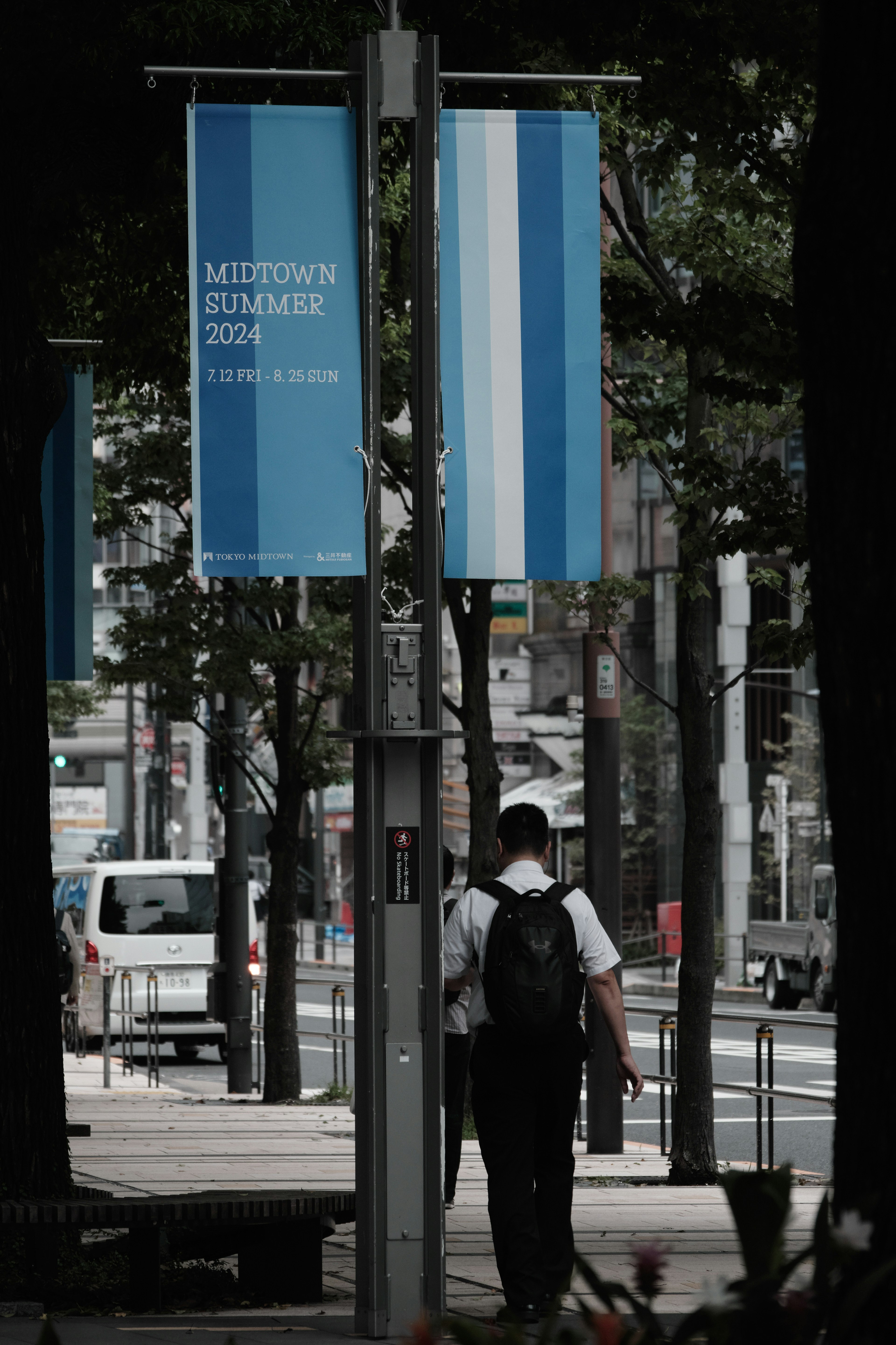 Cityscape featuring blue banners and a person walking