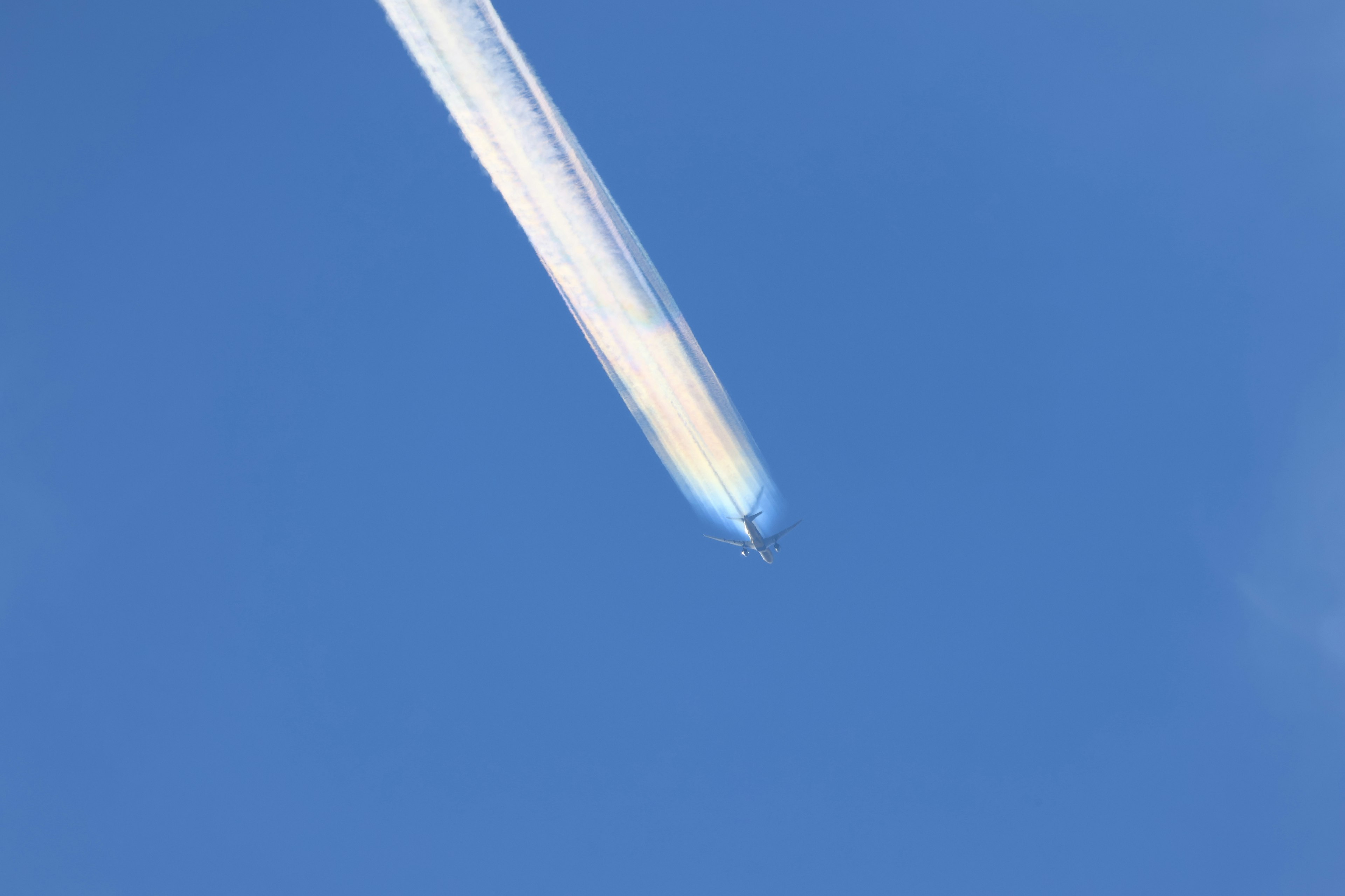 Kondensstreifen eines Flugzeugs vor klarem blauen Himmel