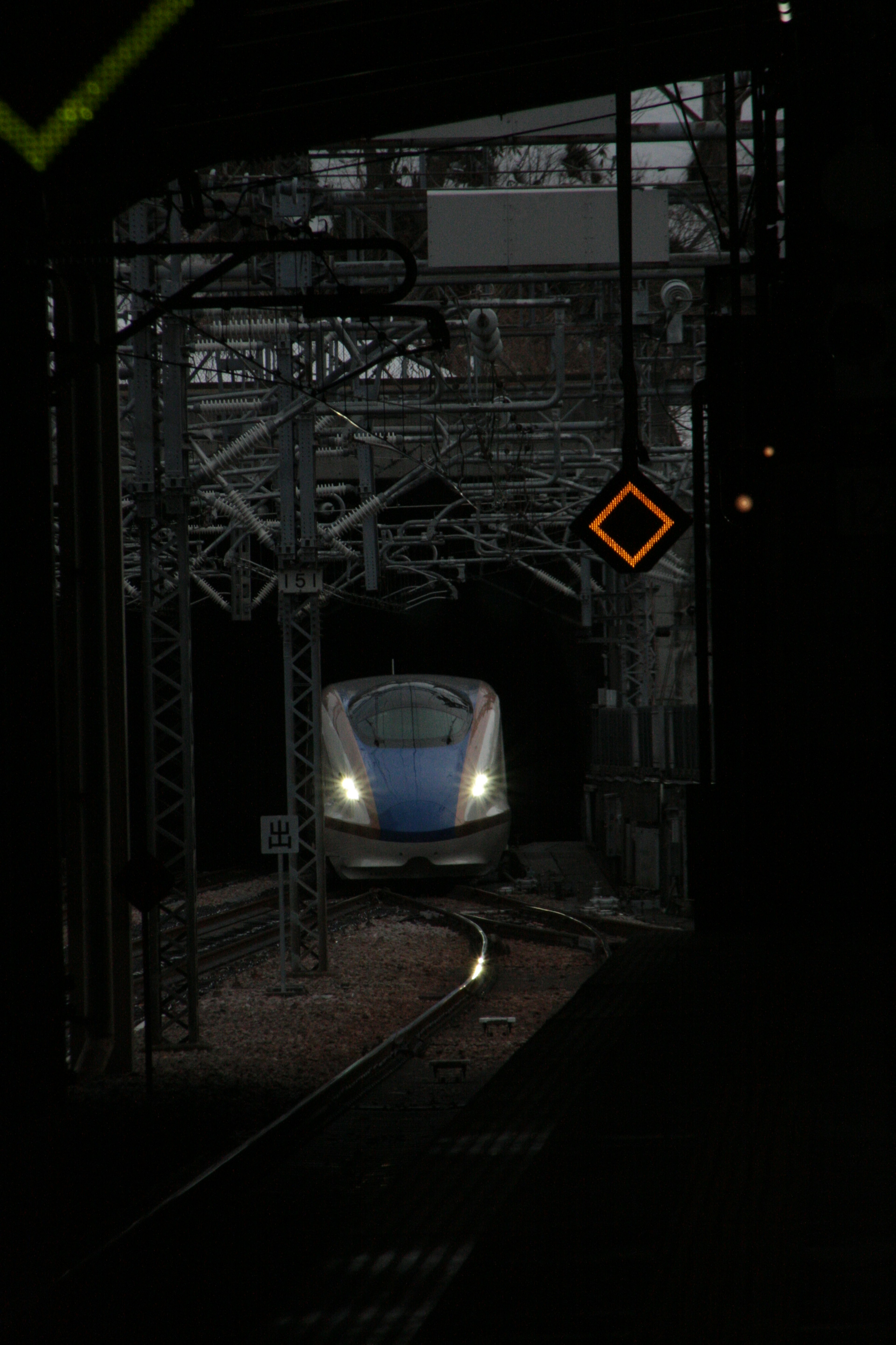 Shinkansen train emerging from a dark tunnel