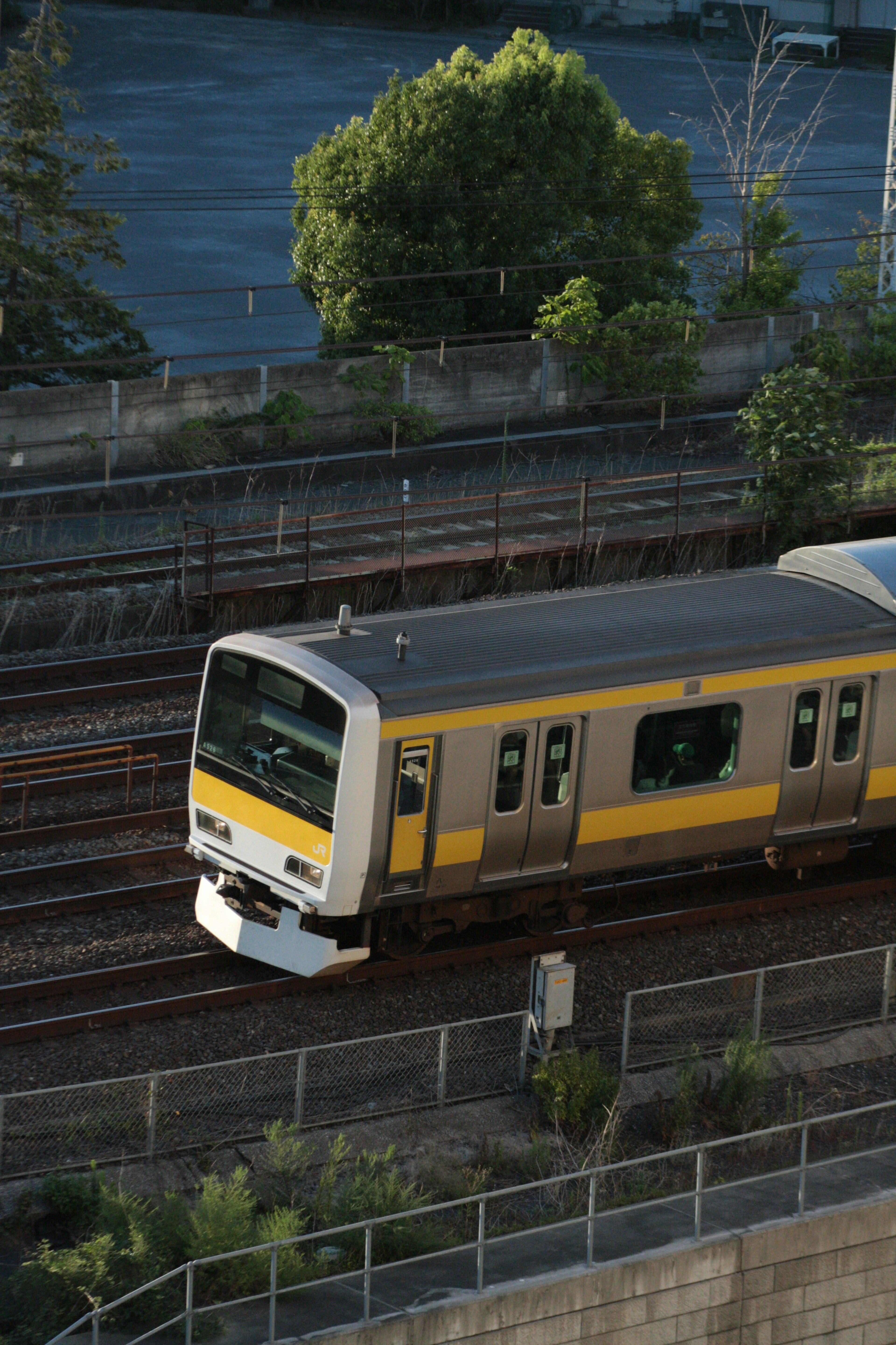 Sebuah kereta kuning dan perak yang melaju di rel