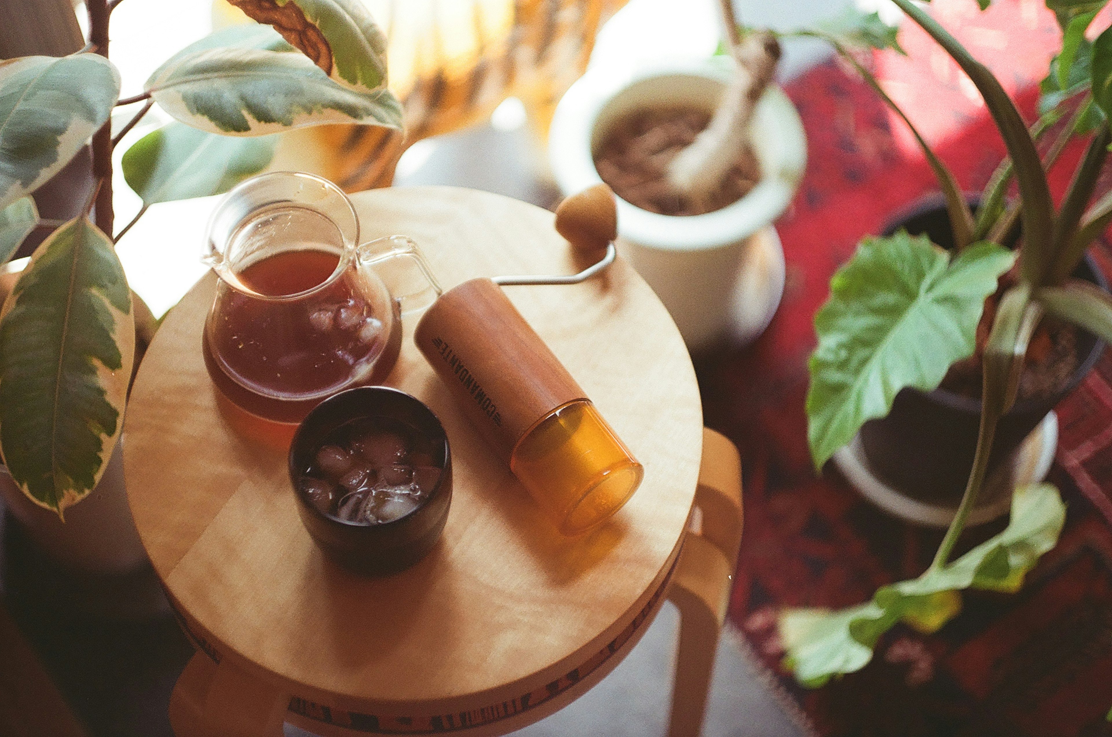 木製のテーブルの上に置かれた茶器と植物のある静かな室内の光景