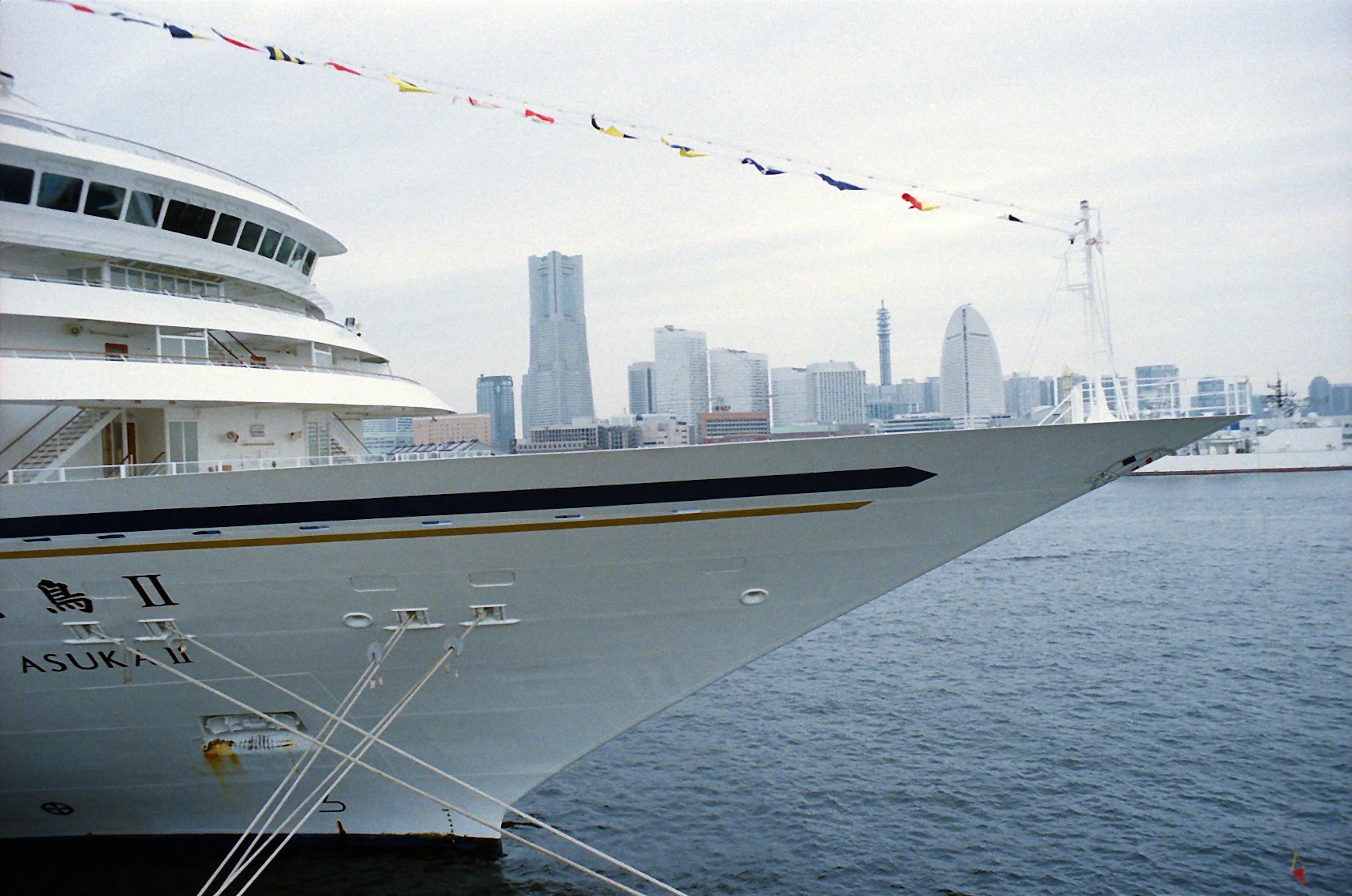 Prua di una nave da crociera di lusso con lo skyline di Yokohama sullo sfondo