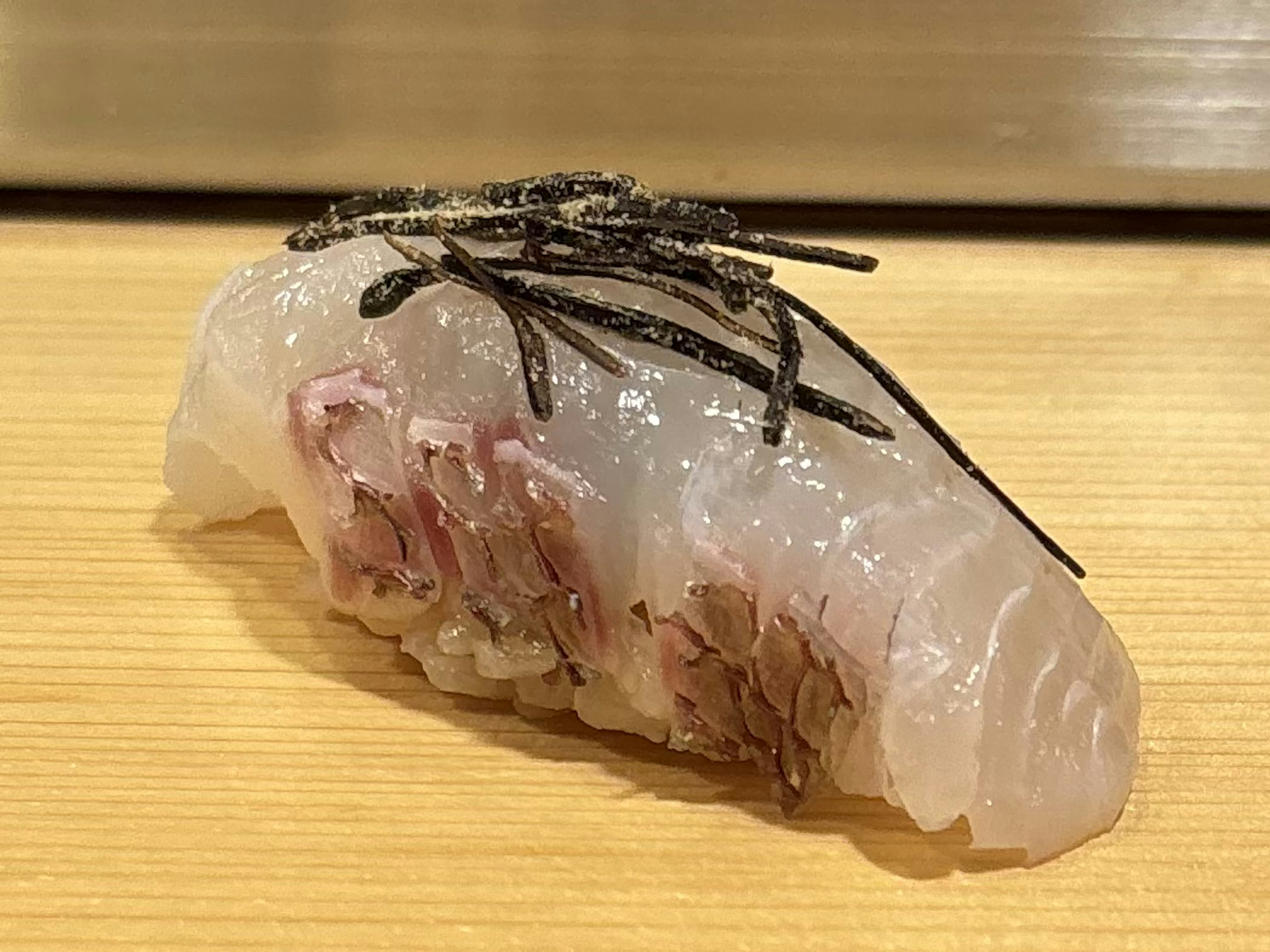 新鮮な魚の握り寿司に海苔がトッピングされた美しい一品