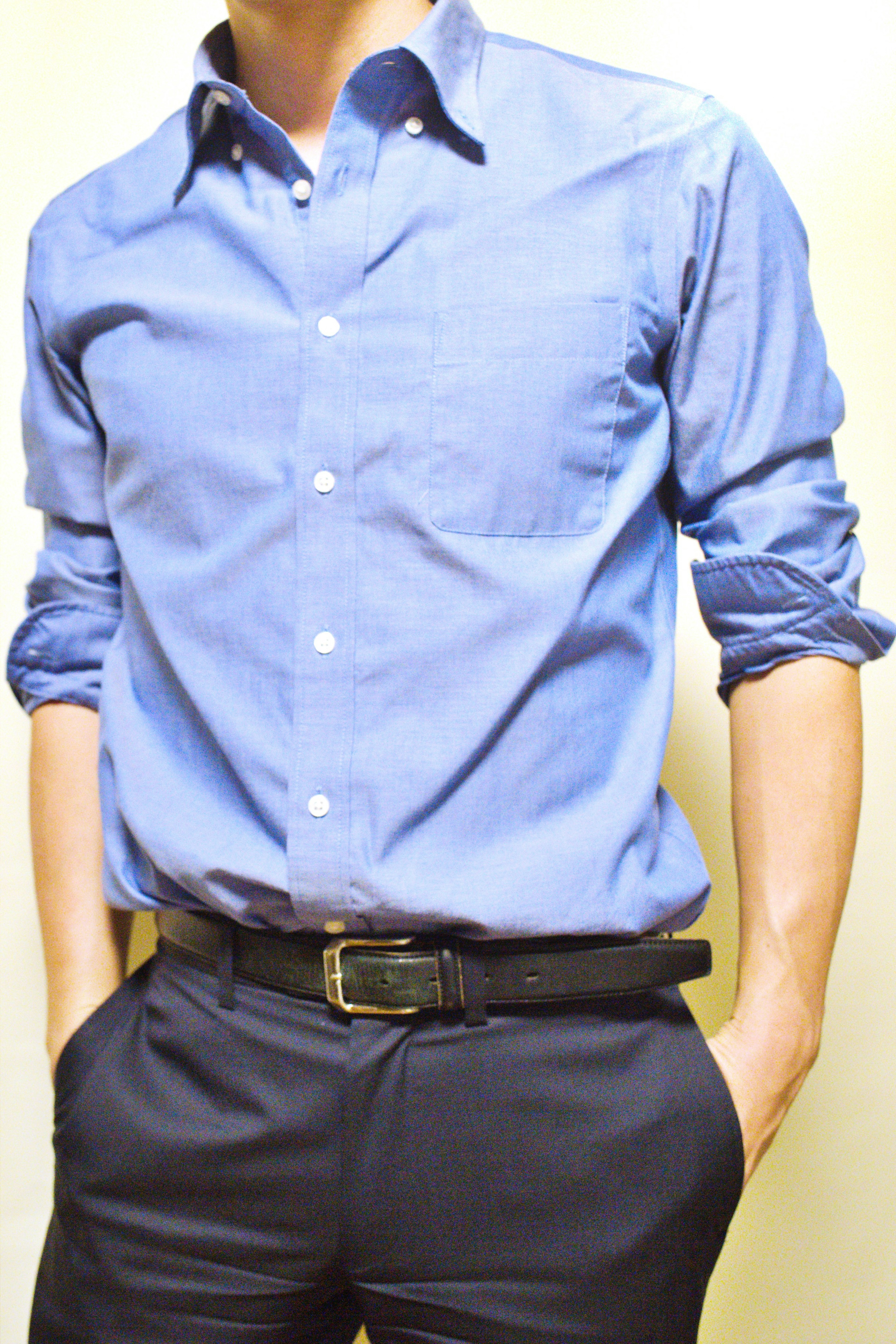 Photo of a man wearing a blue shirt with rolled-up sleeves