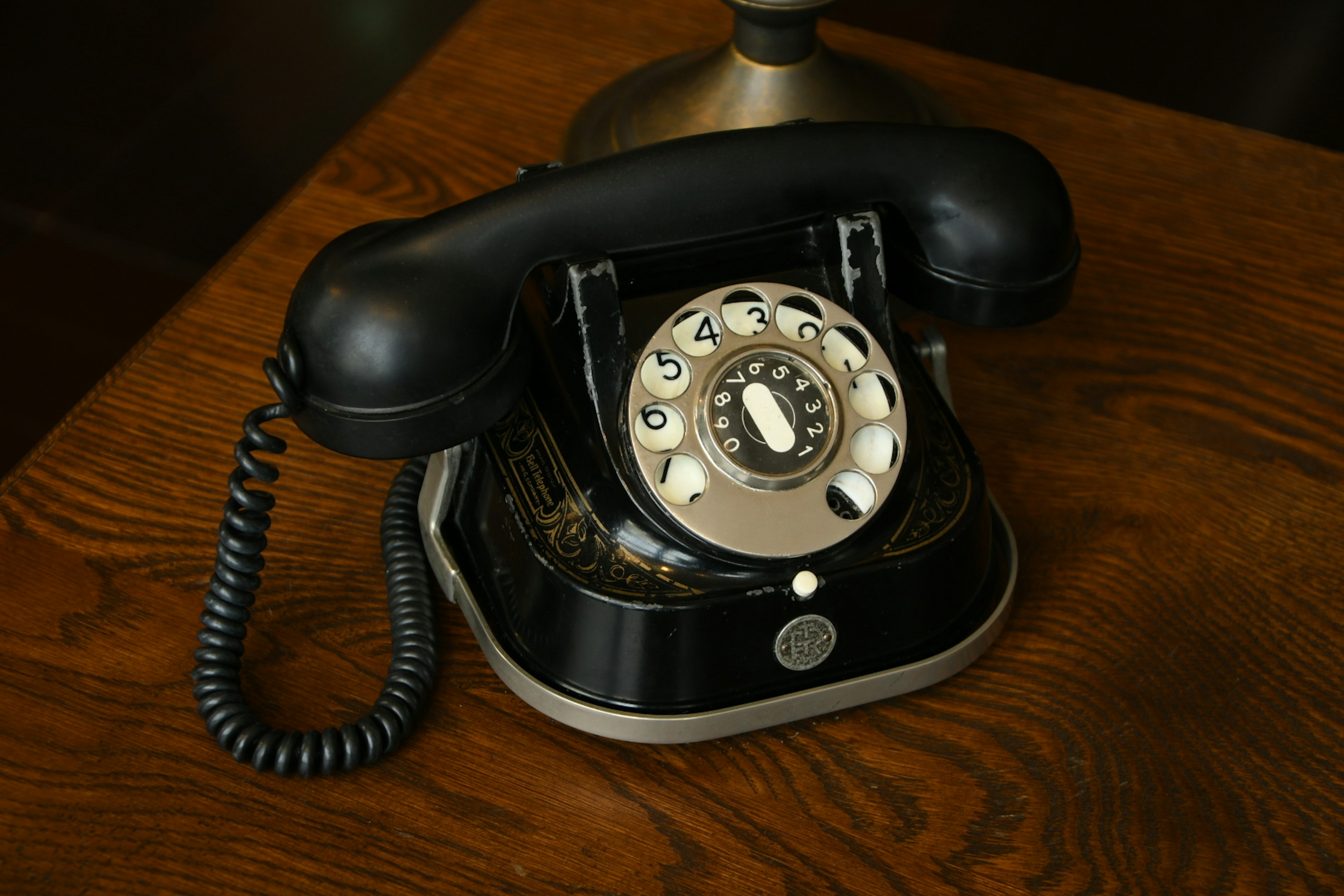 A classic black rotary phone placed on a wooden table