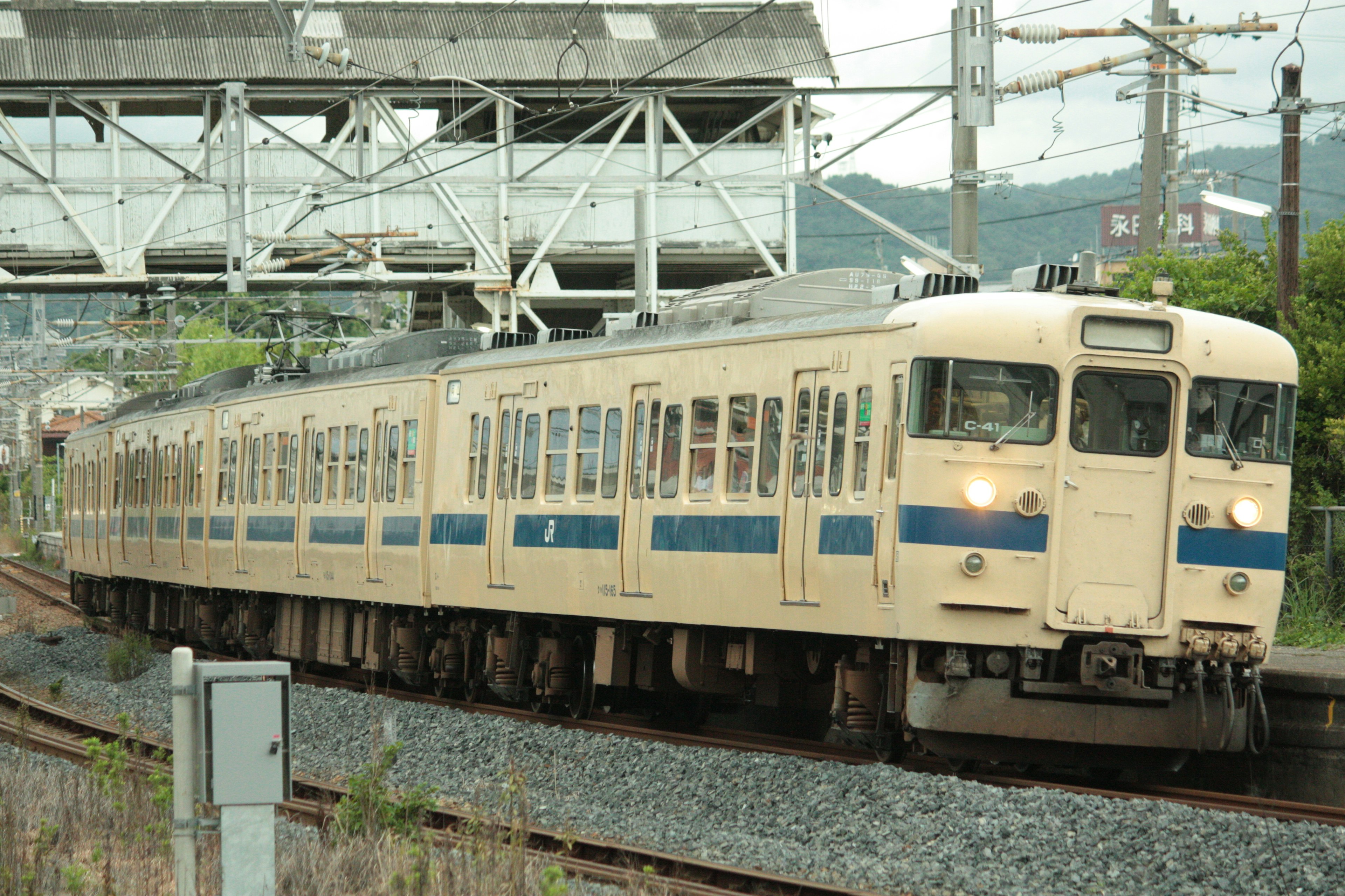 Japanese train with blue and white stripes running on the tracks