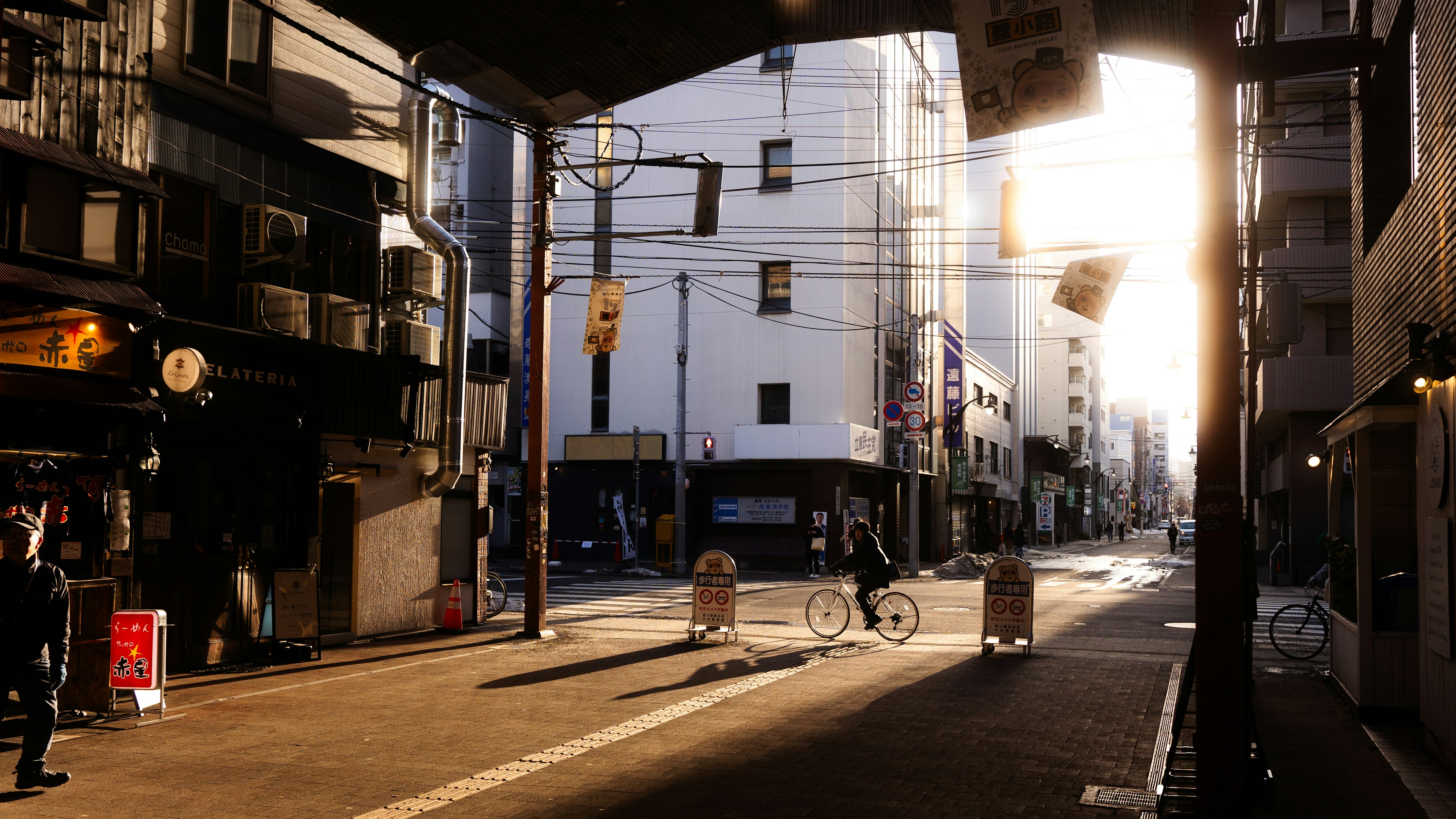 Rue urbaine au coucher du soleil avec des gens marchant et une lumière douce