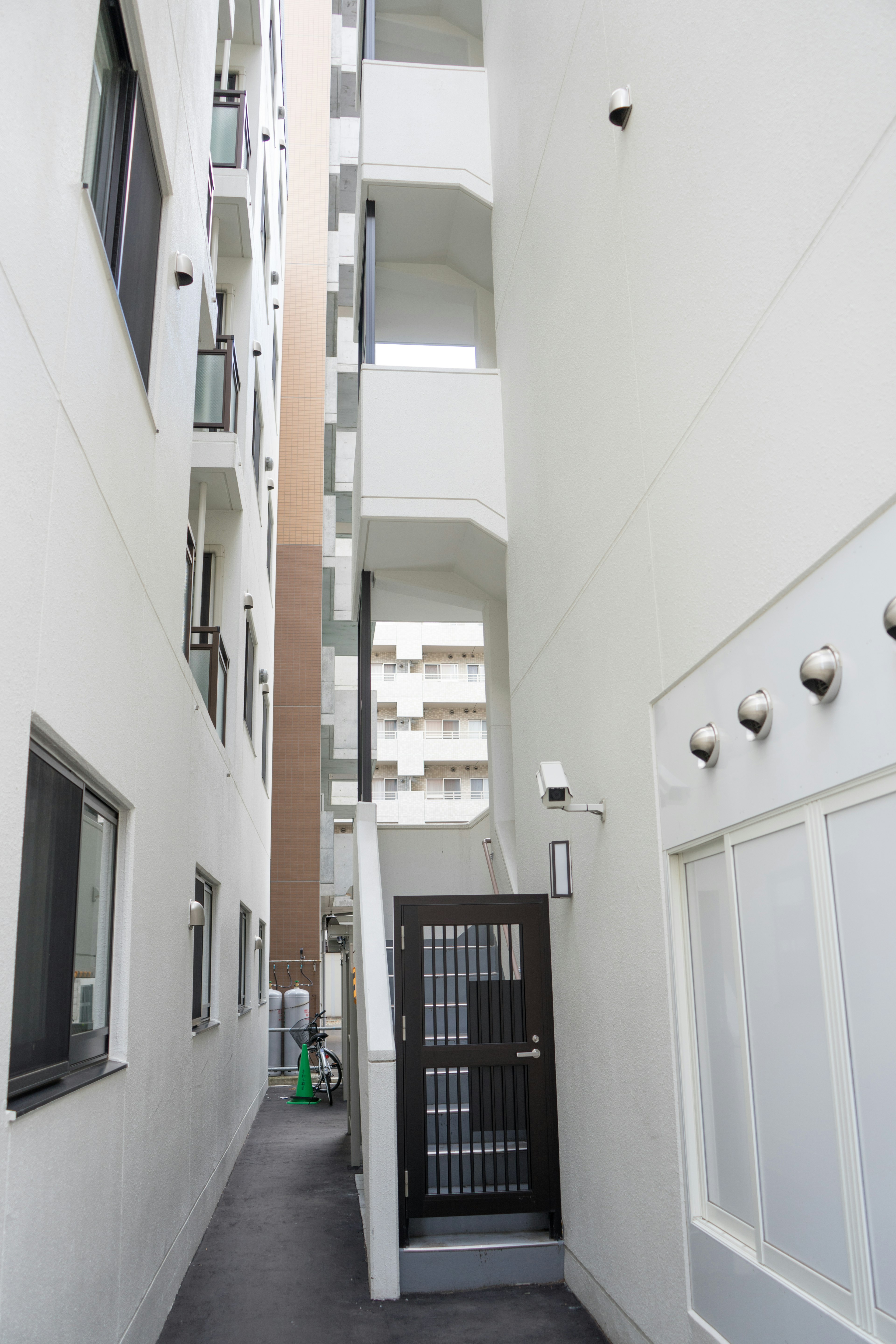 Passage étroit avec des murs blancs et des escaliers dans un bâtiment