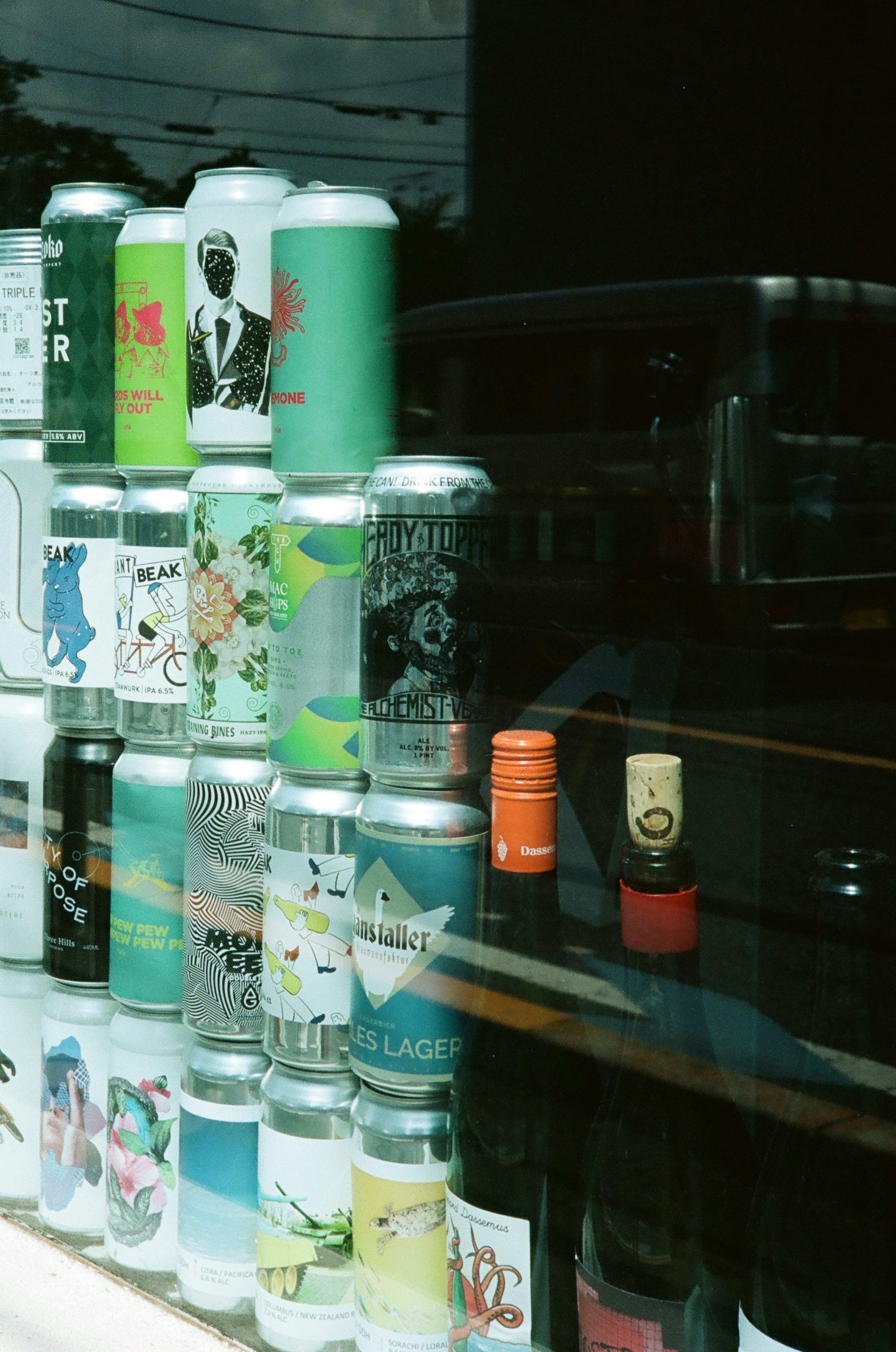 Colorful beer cans displayed behind a window