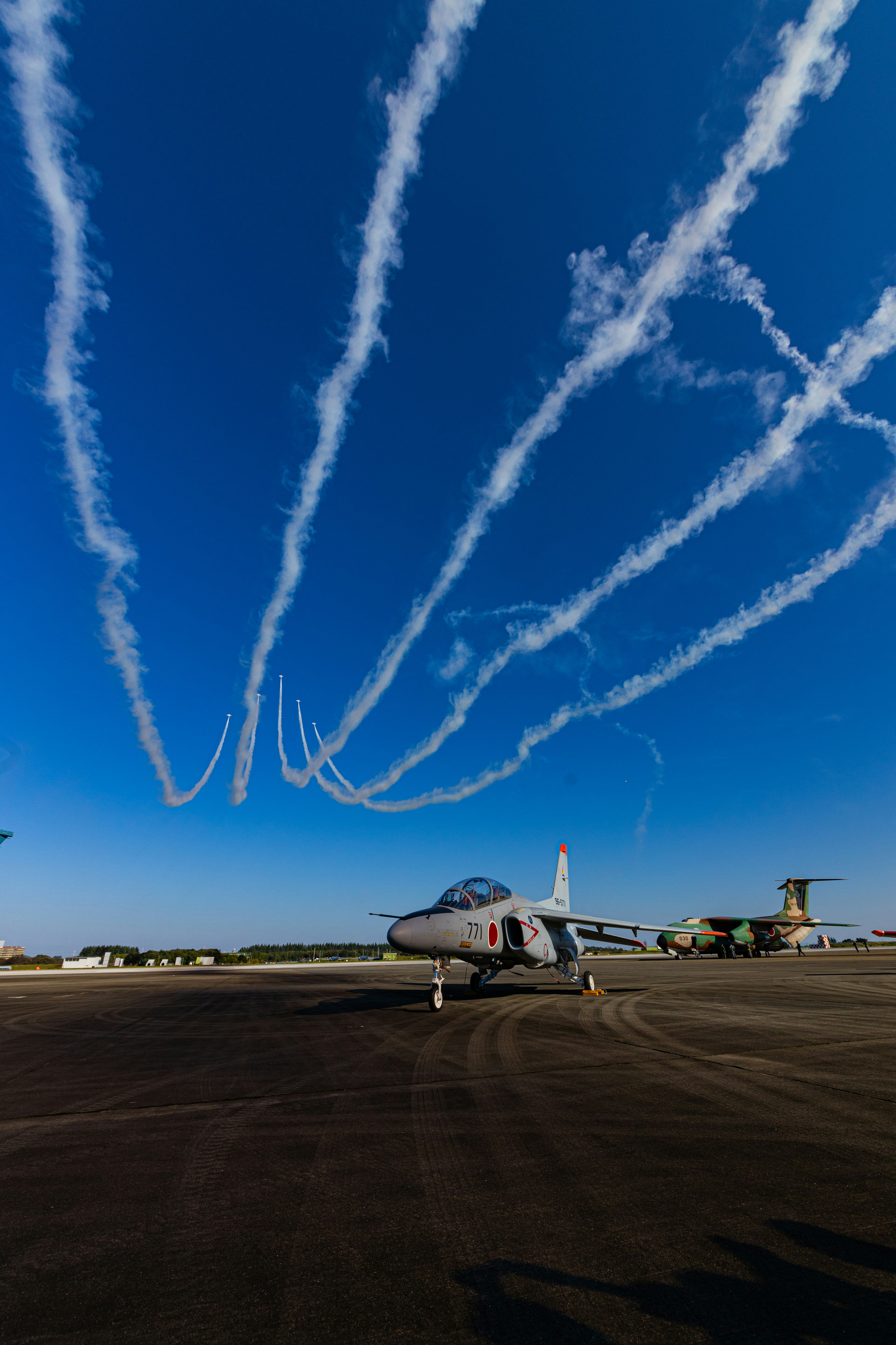 青空に飛行機雲が描くスパイラルの軌跡と航空機