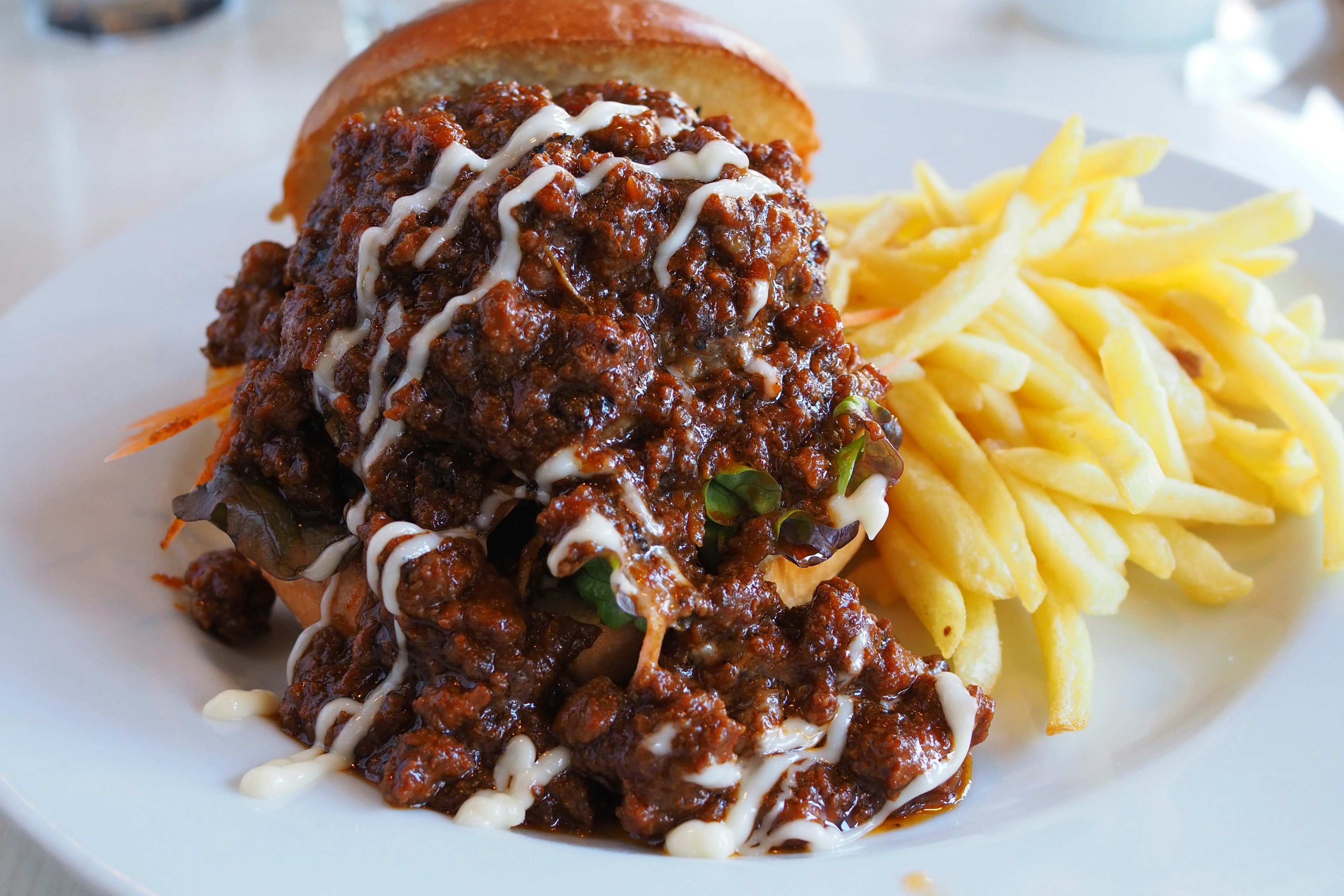 Üppiger Burger mit herzhaftem Fleischsoße und goldenen Pommes