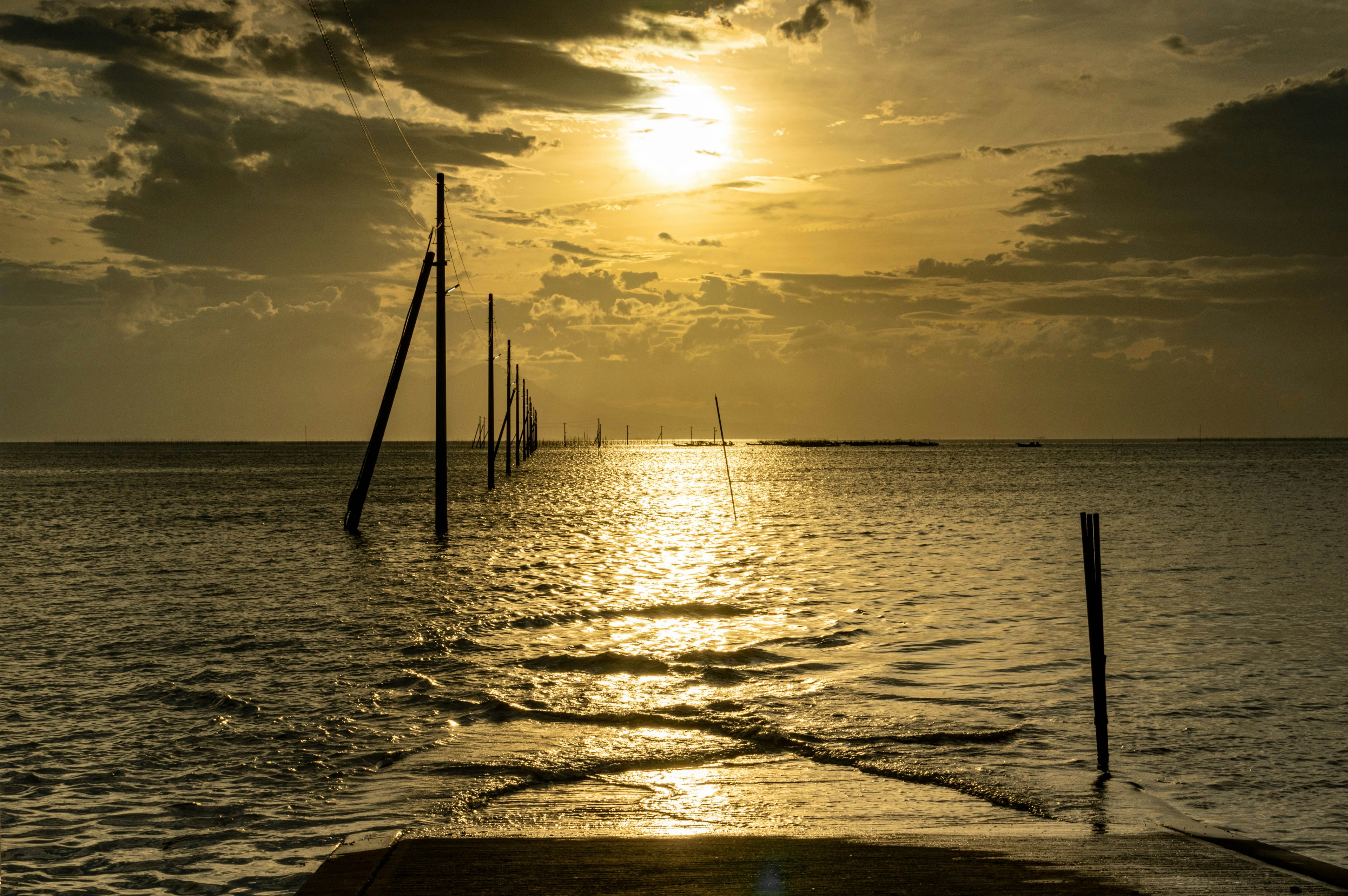 Silhouettes de poteaux dans la mer au coucher du soleil