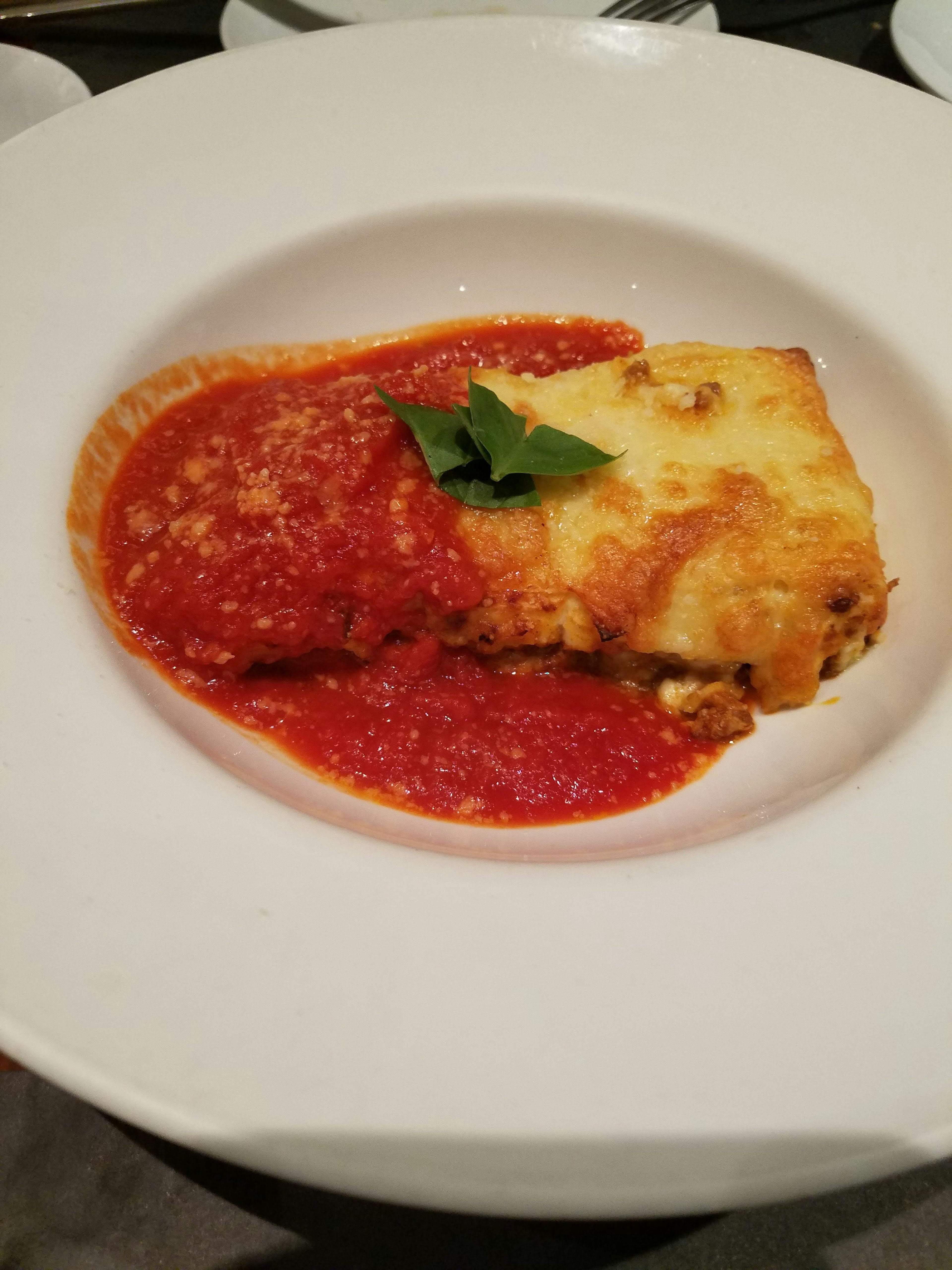 Lasagna servita con salsa di pomodoro su un piatto bianco