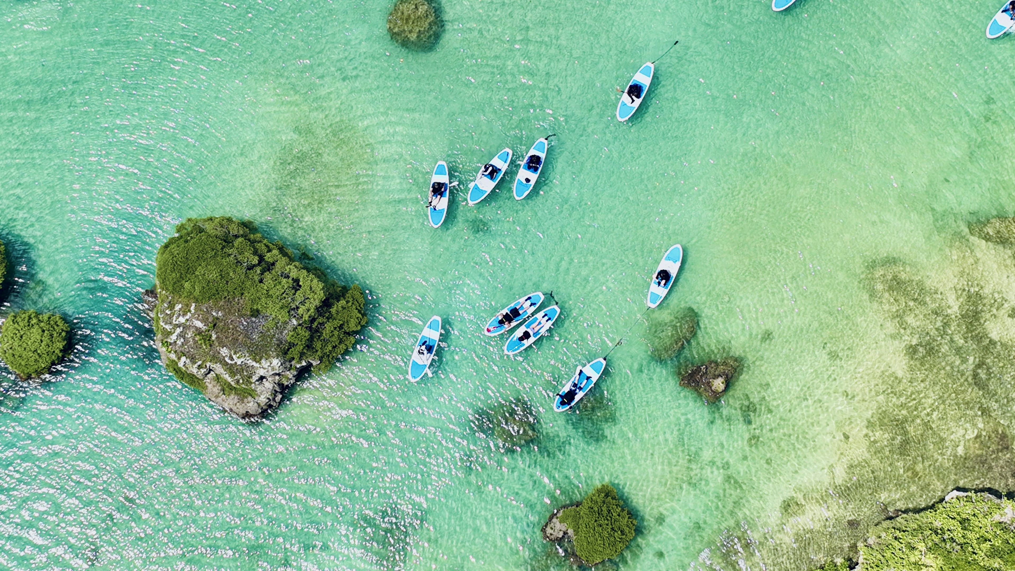 Vue aérienne de kayaks bleus sur une mer turquoise claire