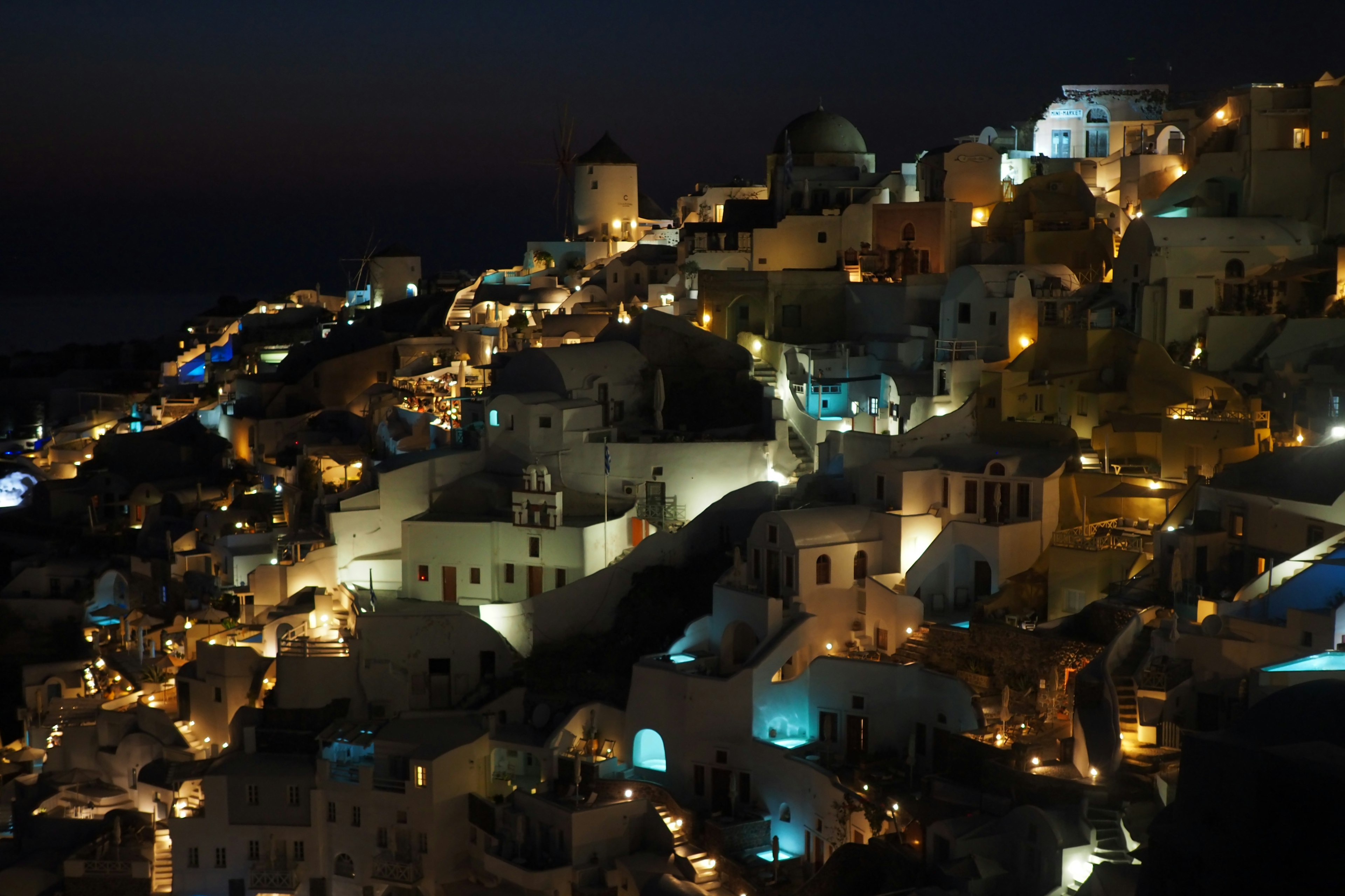 Hermosa vista nocturna de Santorini Edificios blancos iluminados con luces