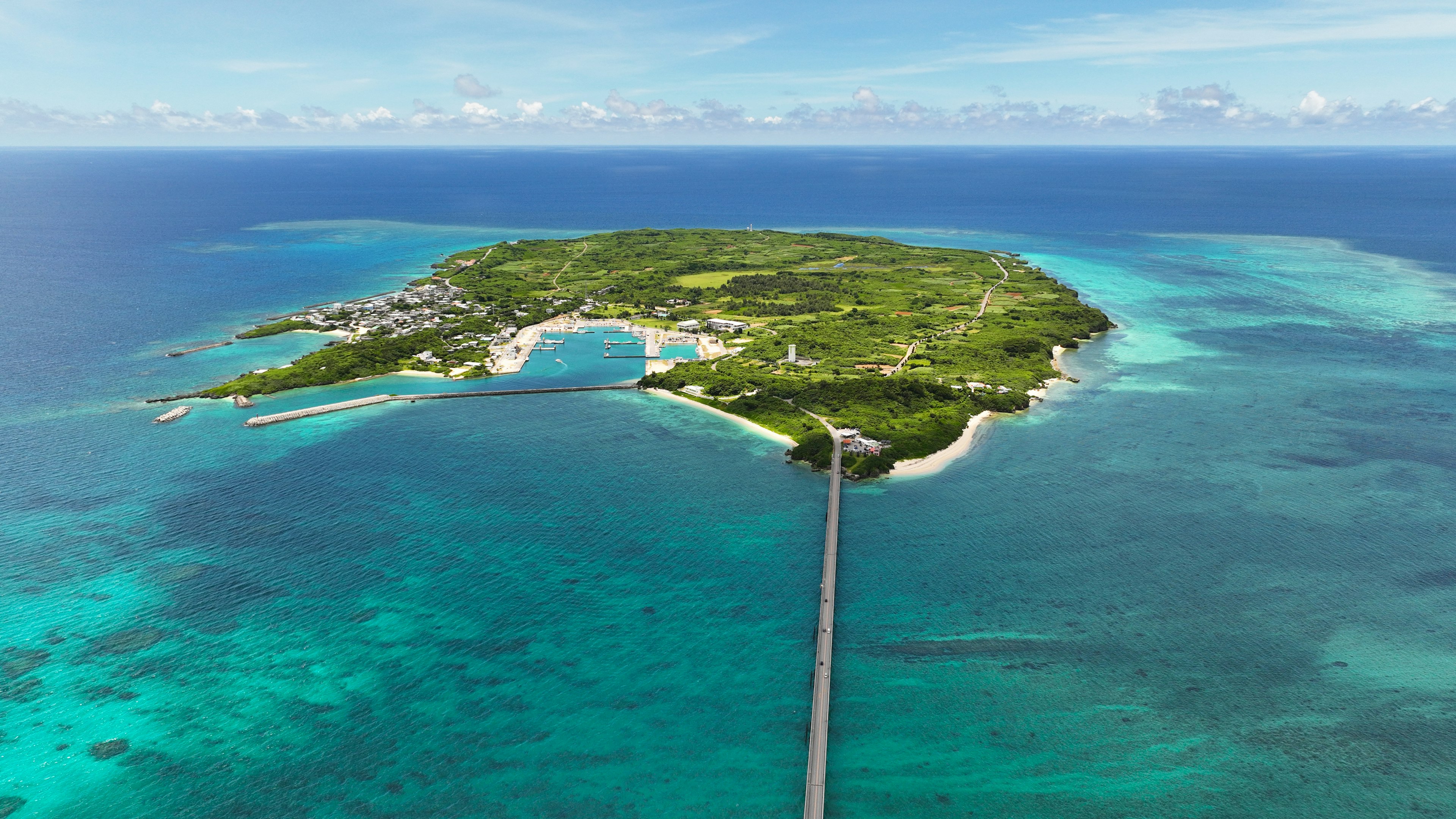 Pandangan udara sebuah pulau hijau dikelilingi air biru dan jembatan