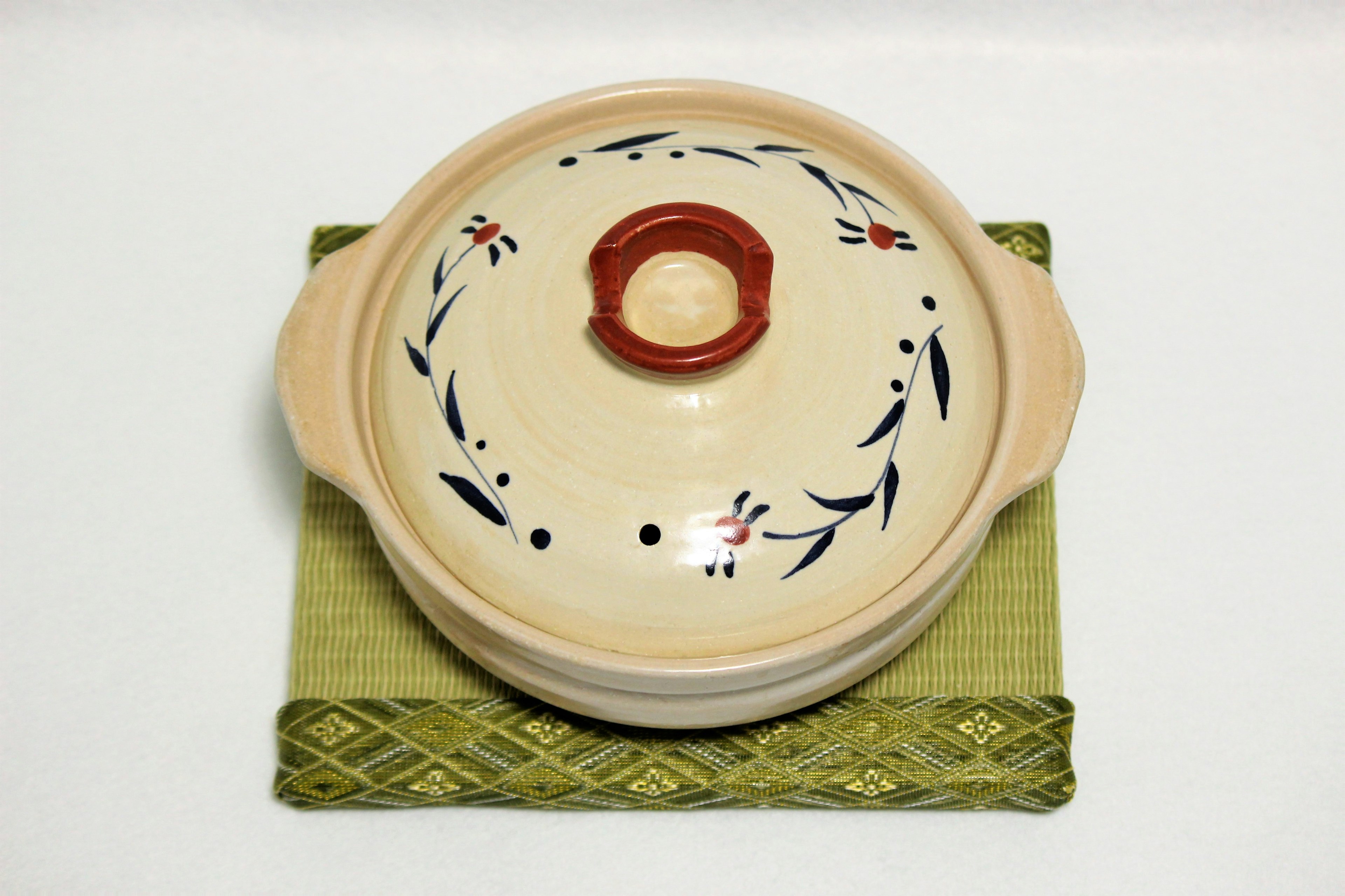 Decorative ceramic pot placed on a green mat