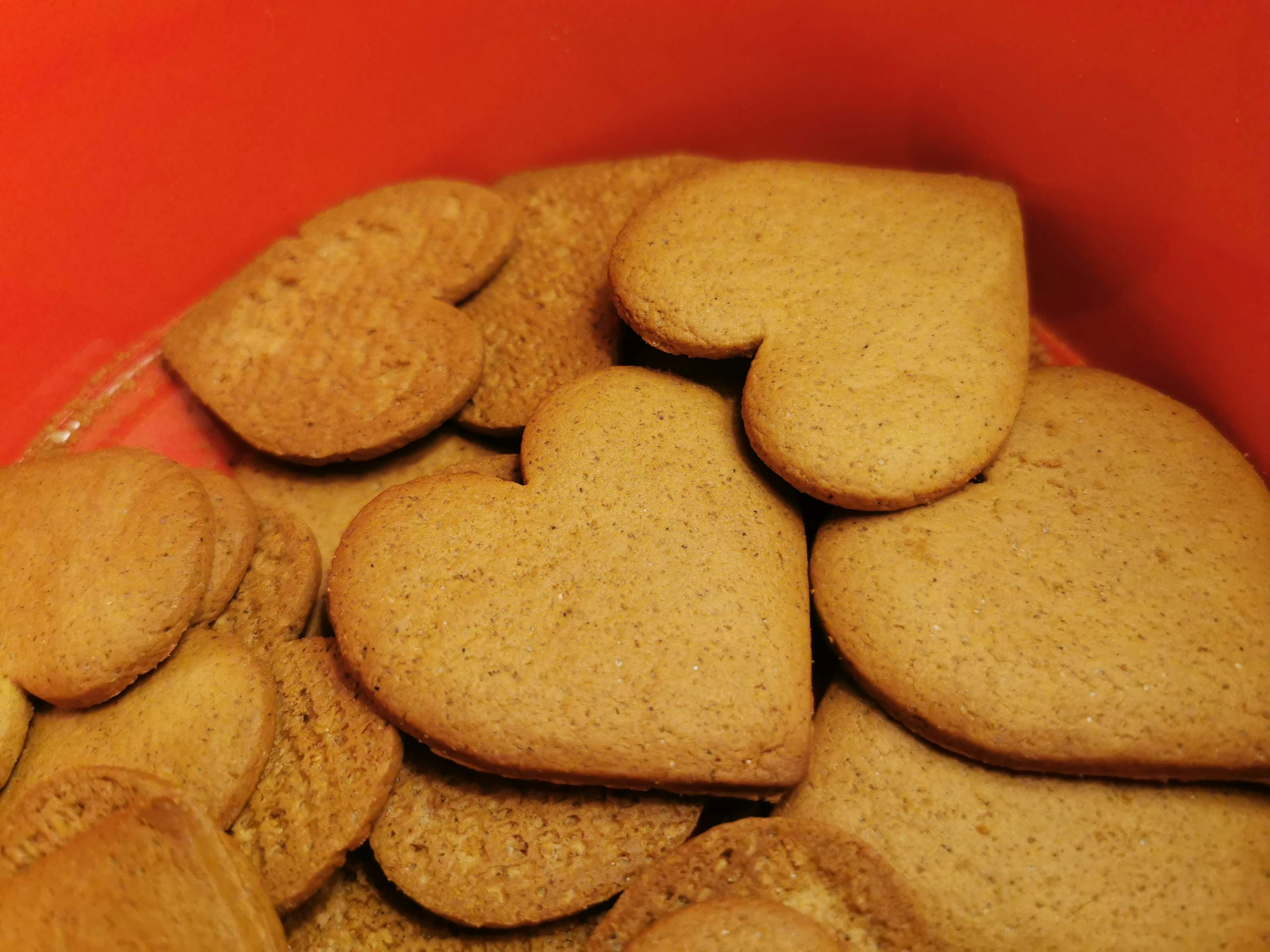 Una colección de galletas en forma de corazón en un recipiente rojo