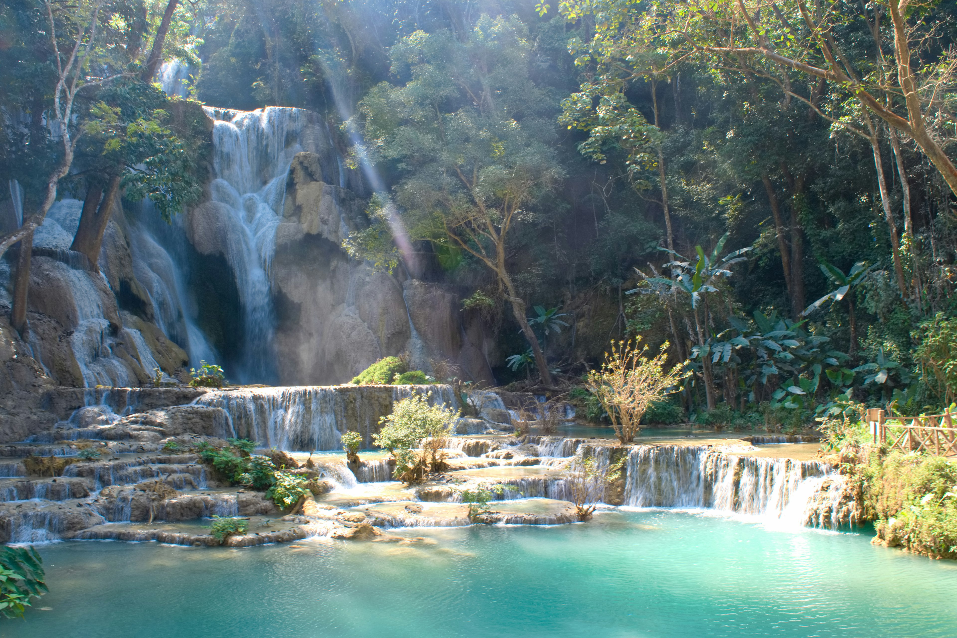 Cascada escénica con piscina turquesa rodeada de exuberante vegetación