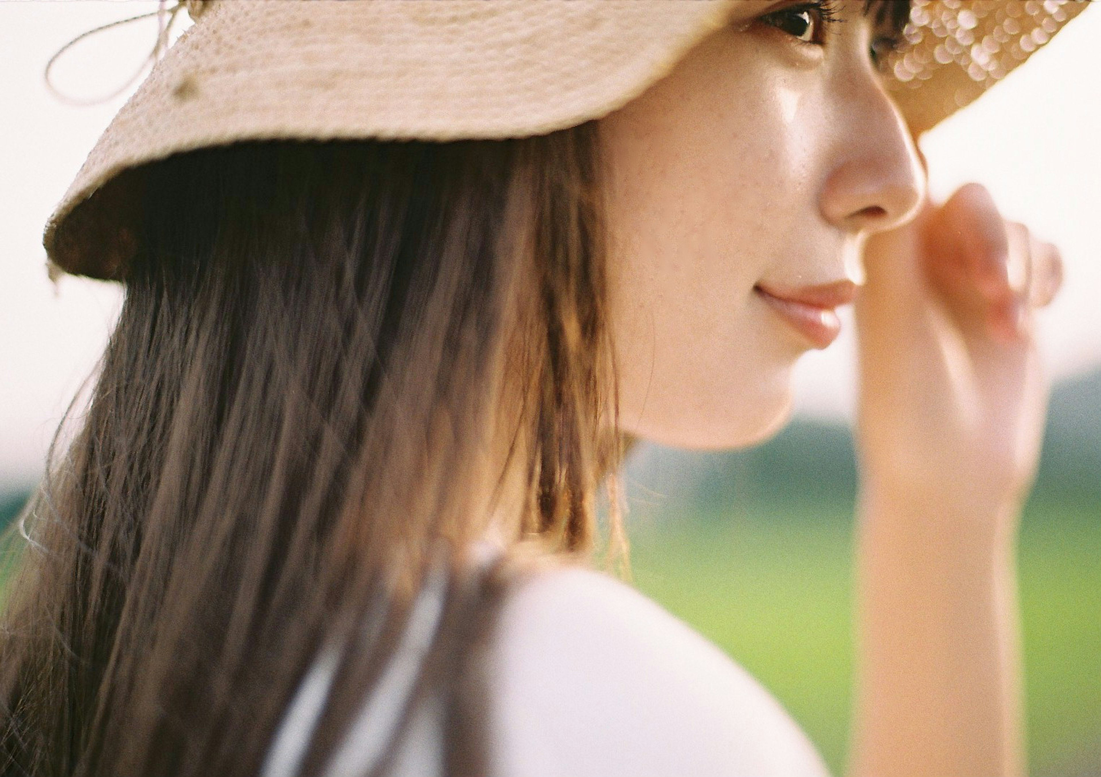 Profilo di una donna con un cappello di paglia Espressione dolce su sfondo verde