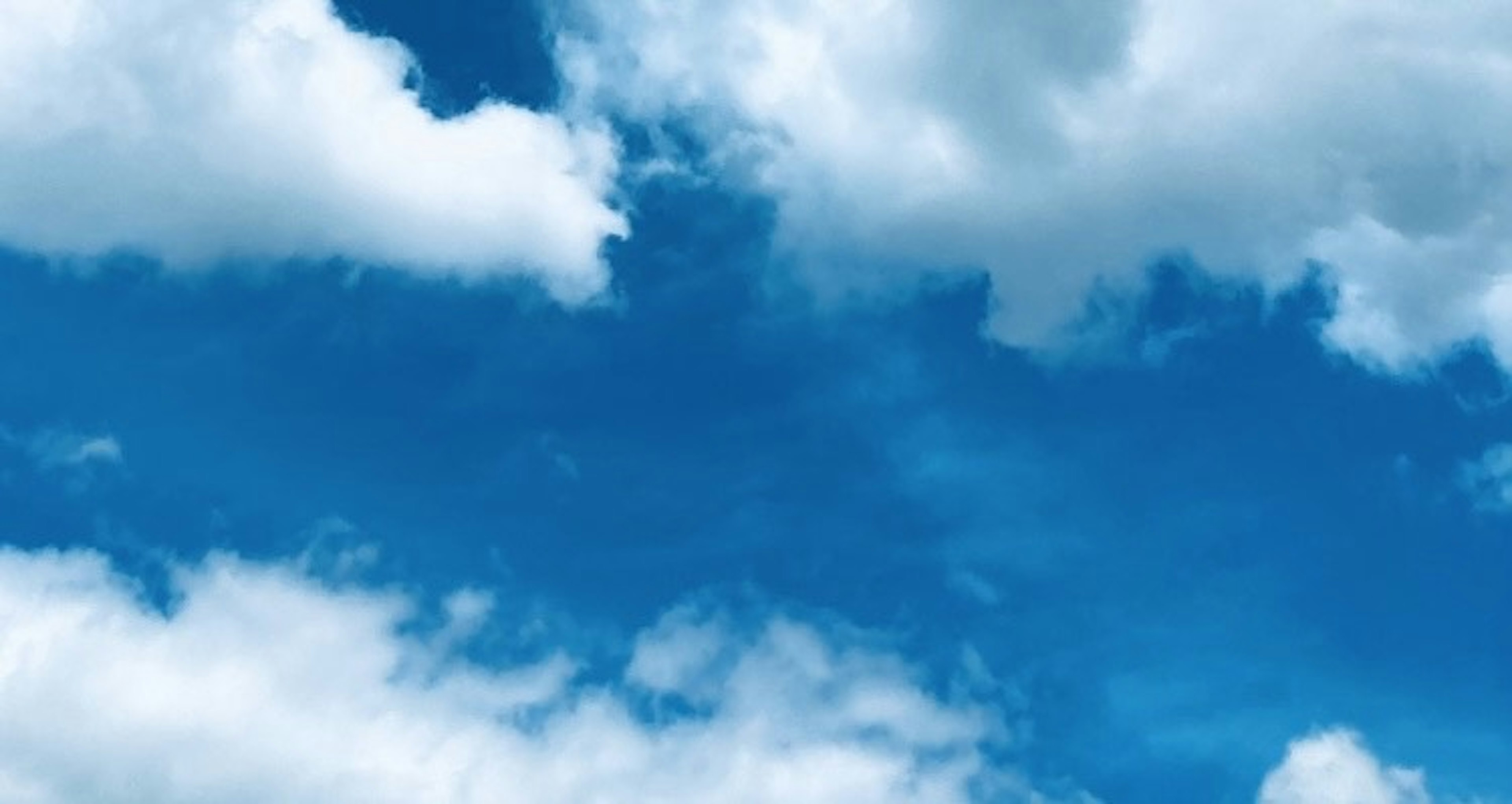 A bright blue sky with fluffy white clouds