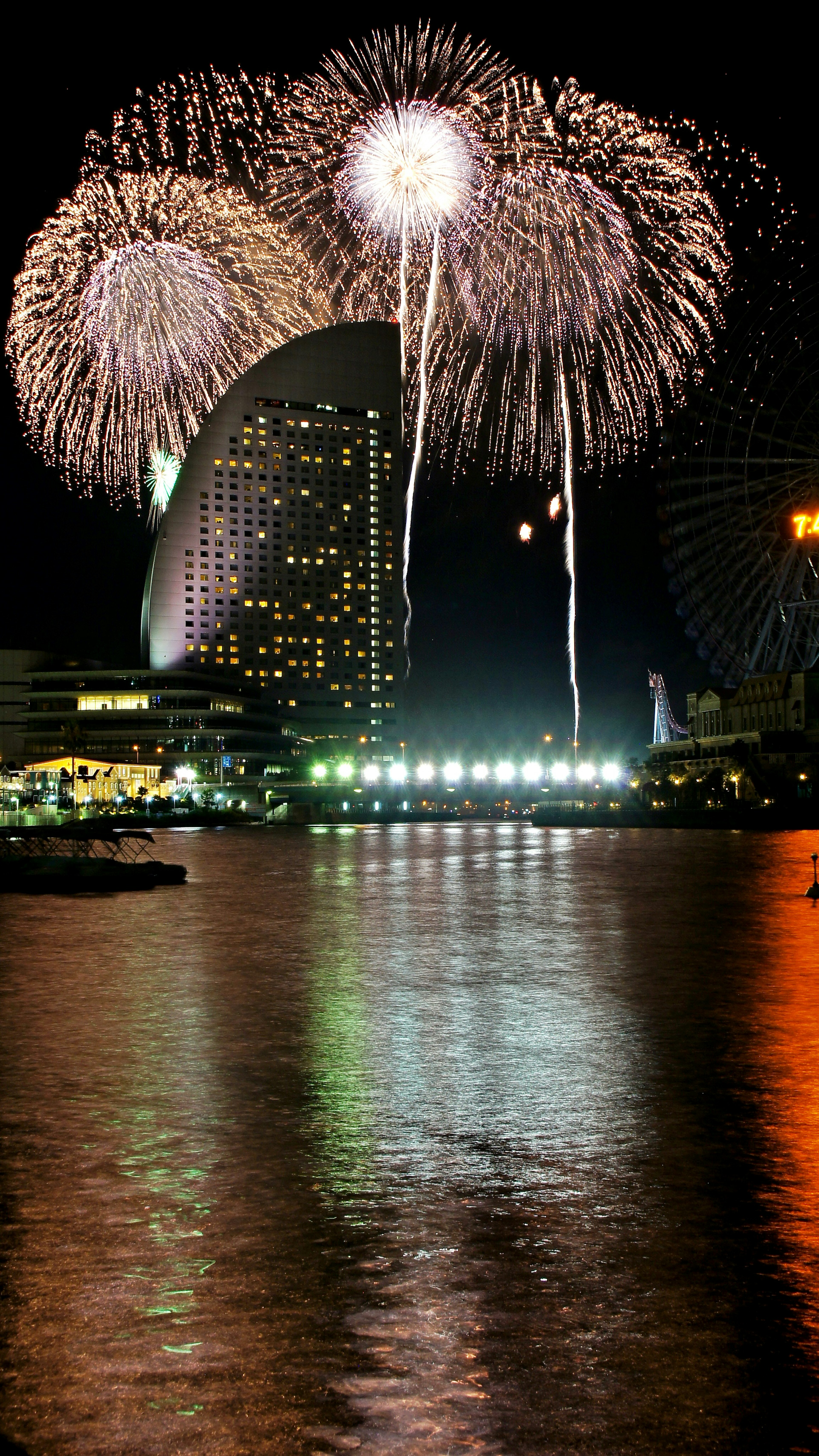 Colorful fireworks display over a waterfront city skyline at night