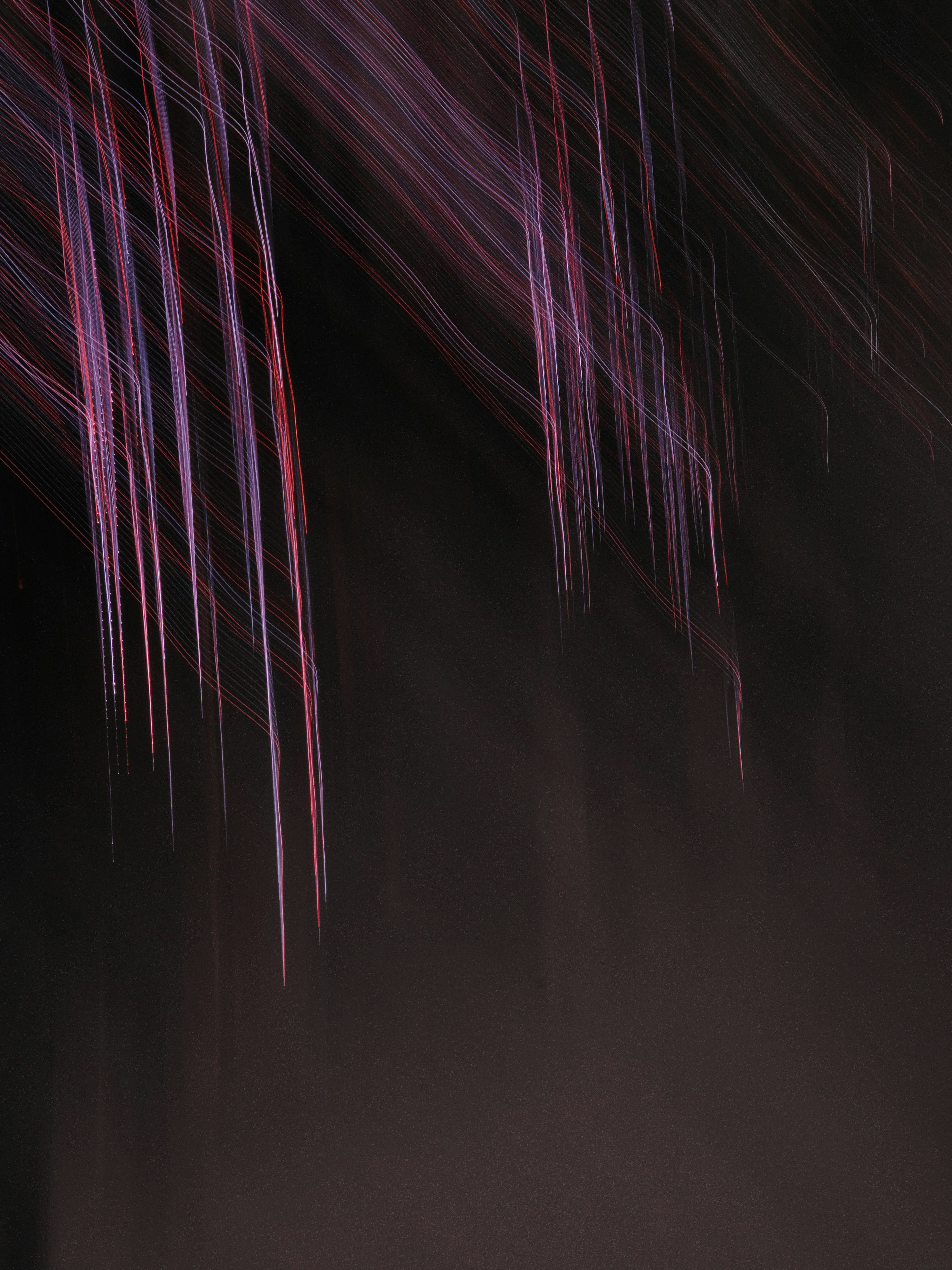 Abstract image with blurred black background and streaks of purple and red