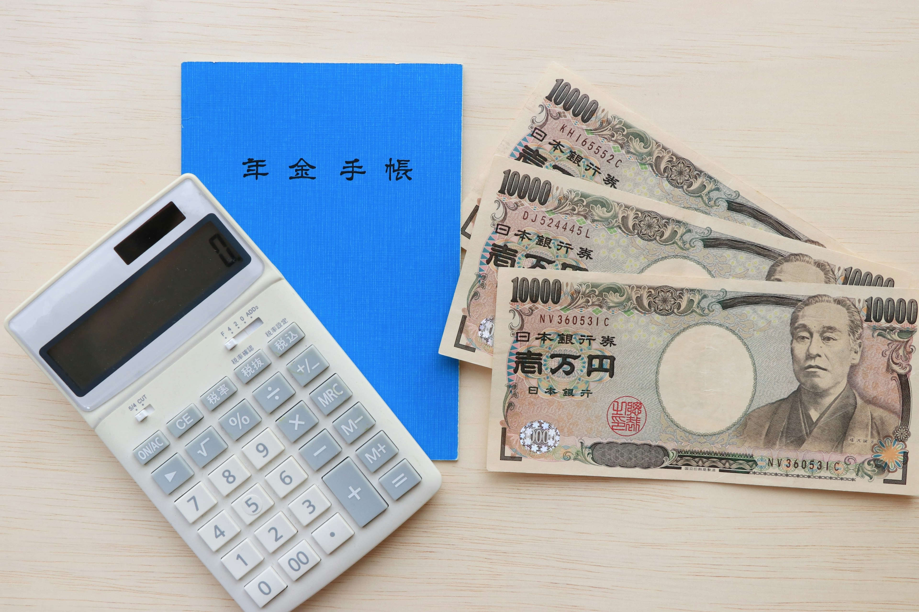 Imagen que muestra un cuaderno azul, una calculadora y billetes de yen japonés