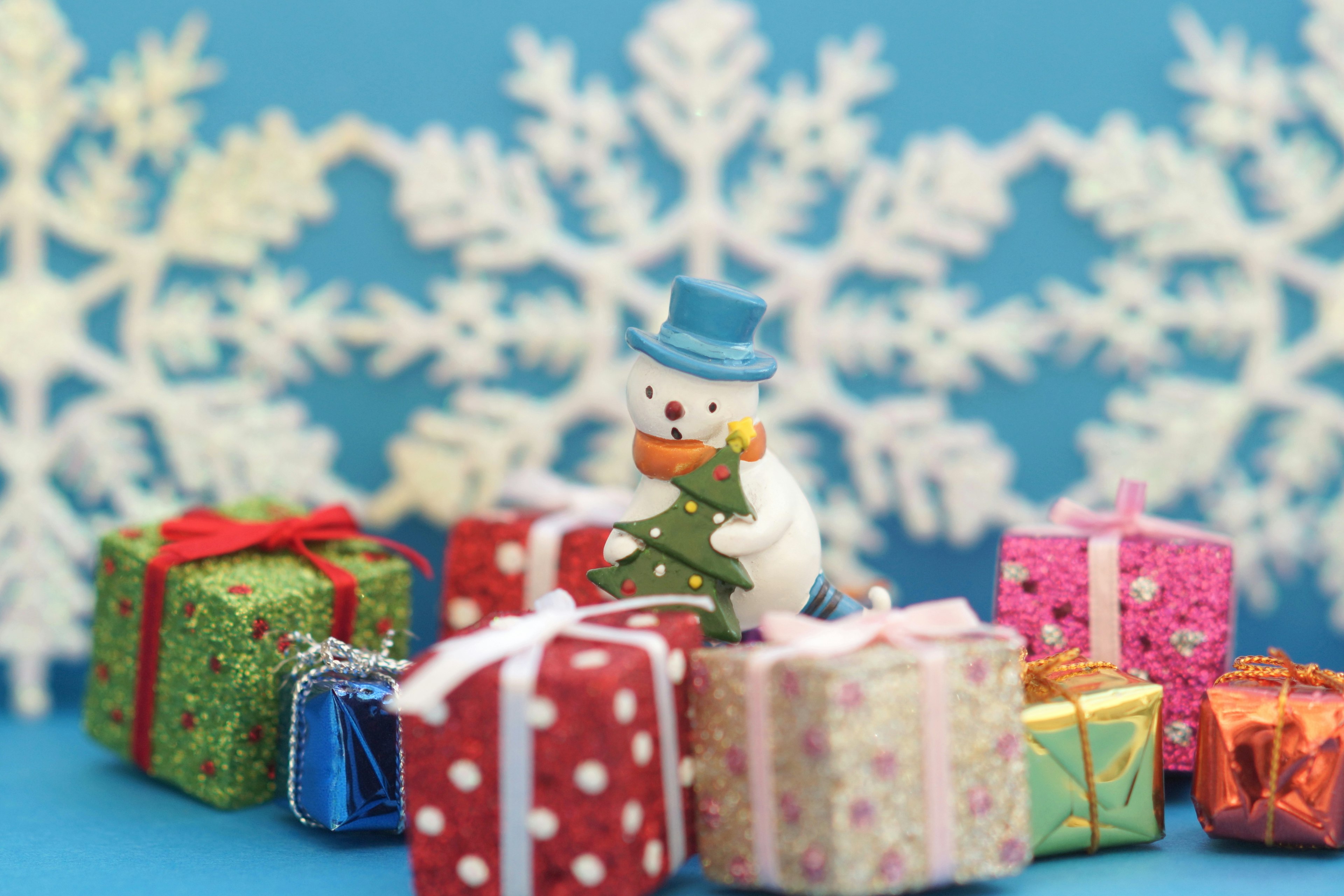 Cadeaux colorés et un bonhomme de neige sur fond de flocons de neige