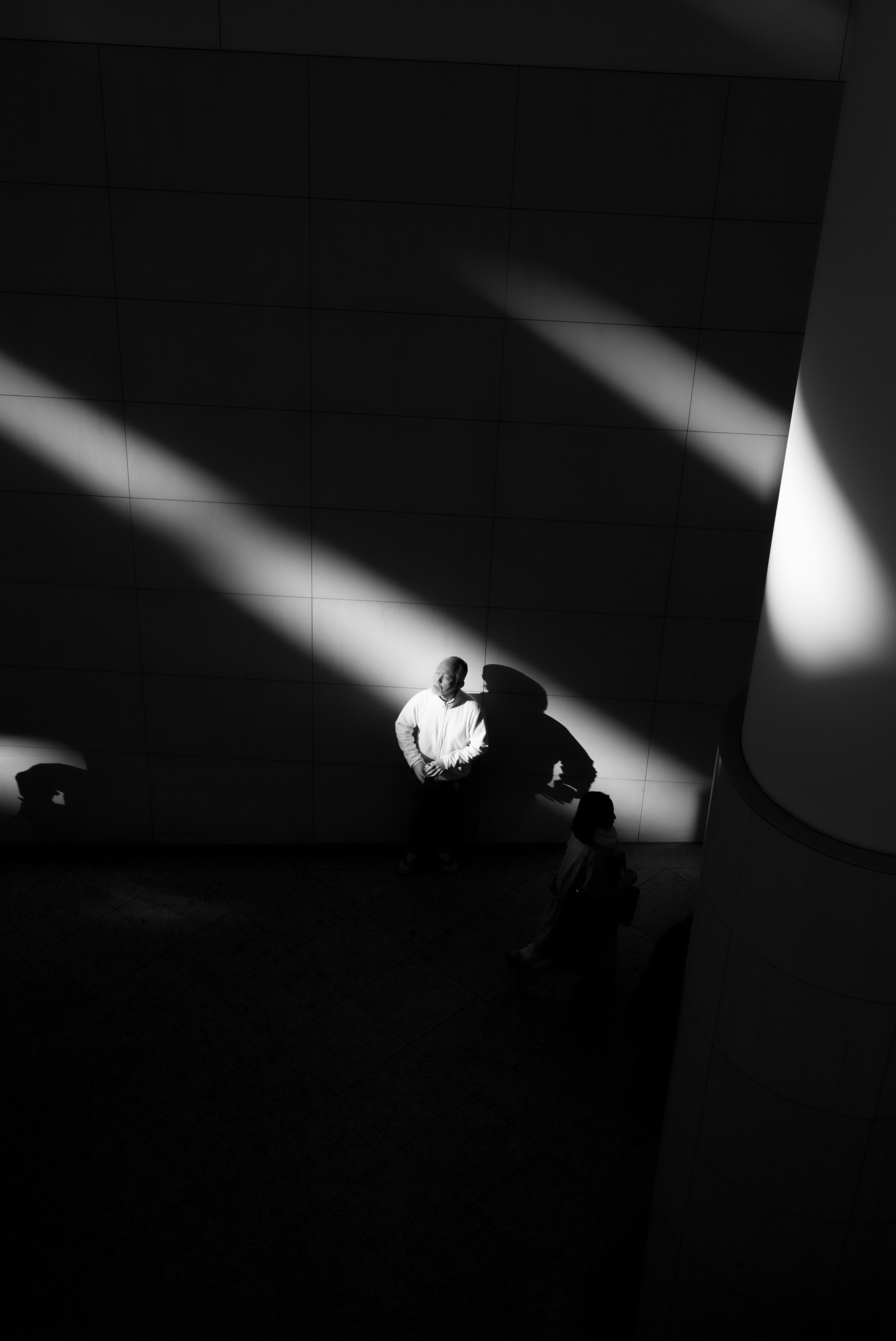 A dramatic scene with contrasting shadows and light featuring two figures