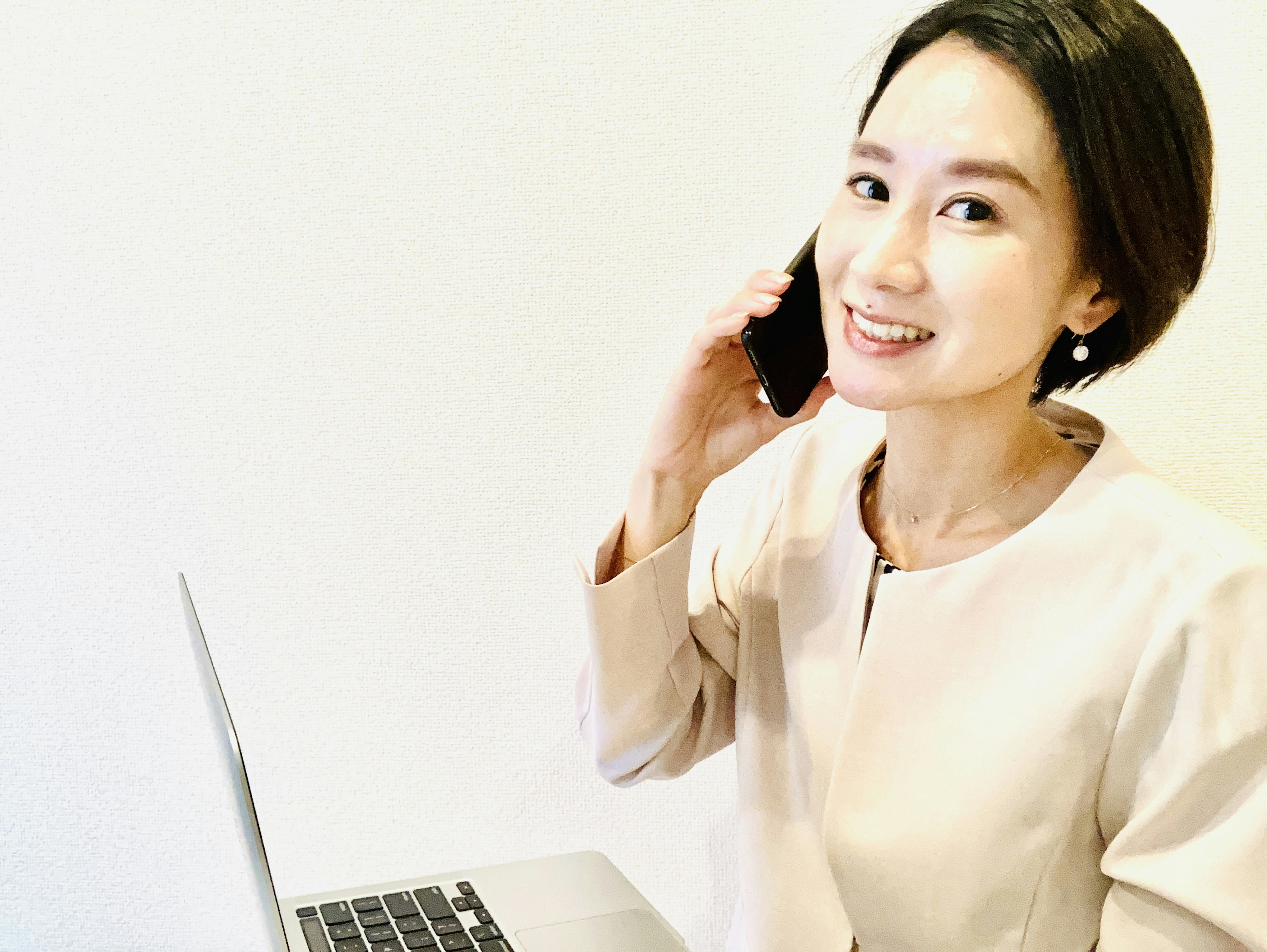 A woman talking on the phone while sitting in front of a laptop