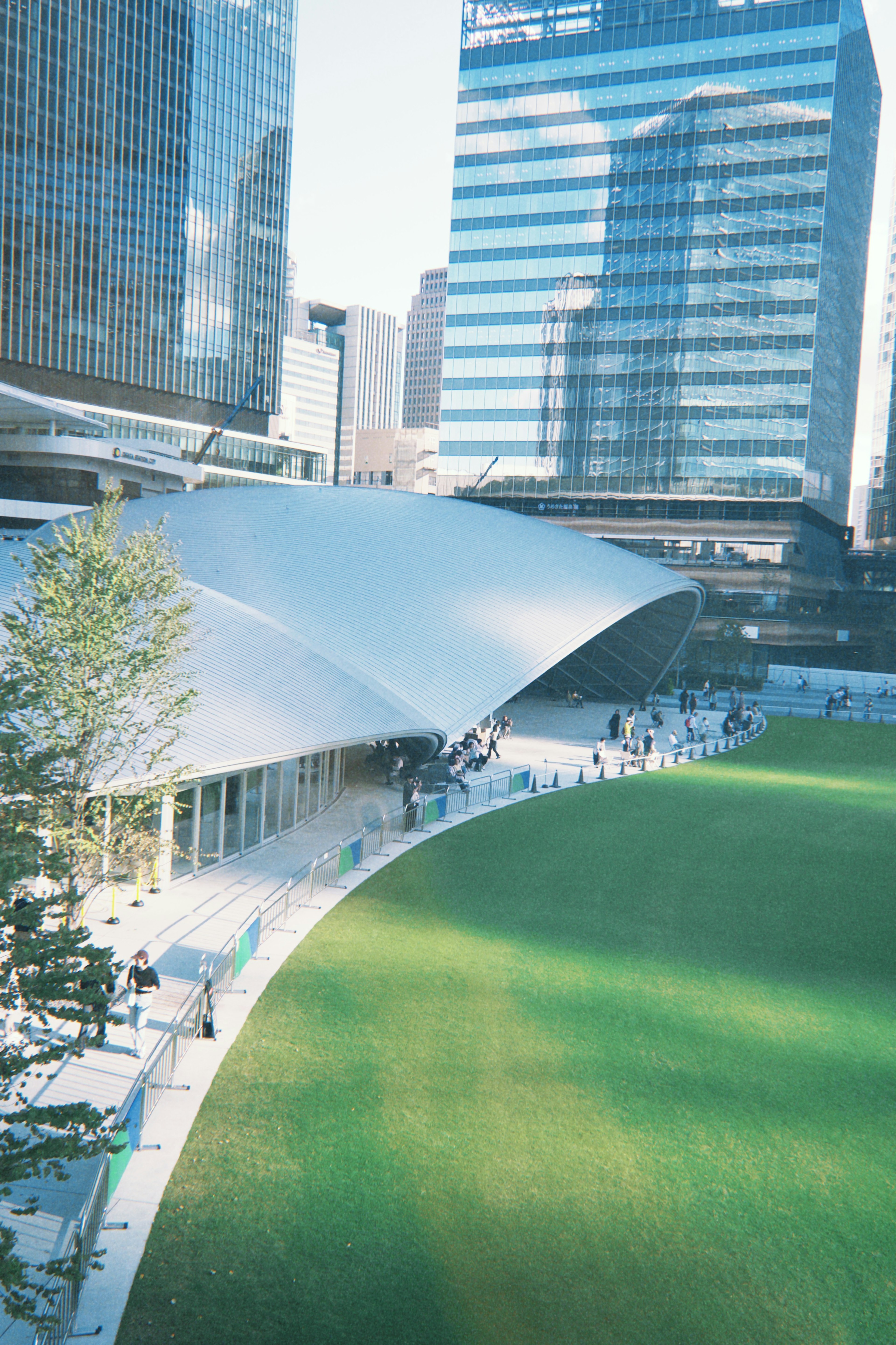 Parc vert spacieux avec une architecture moderne entourée de gratte-ciel