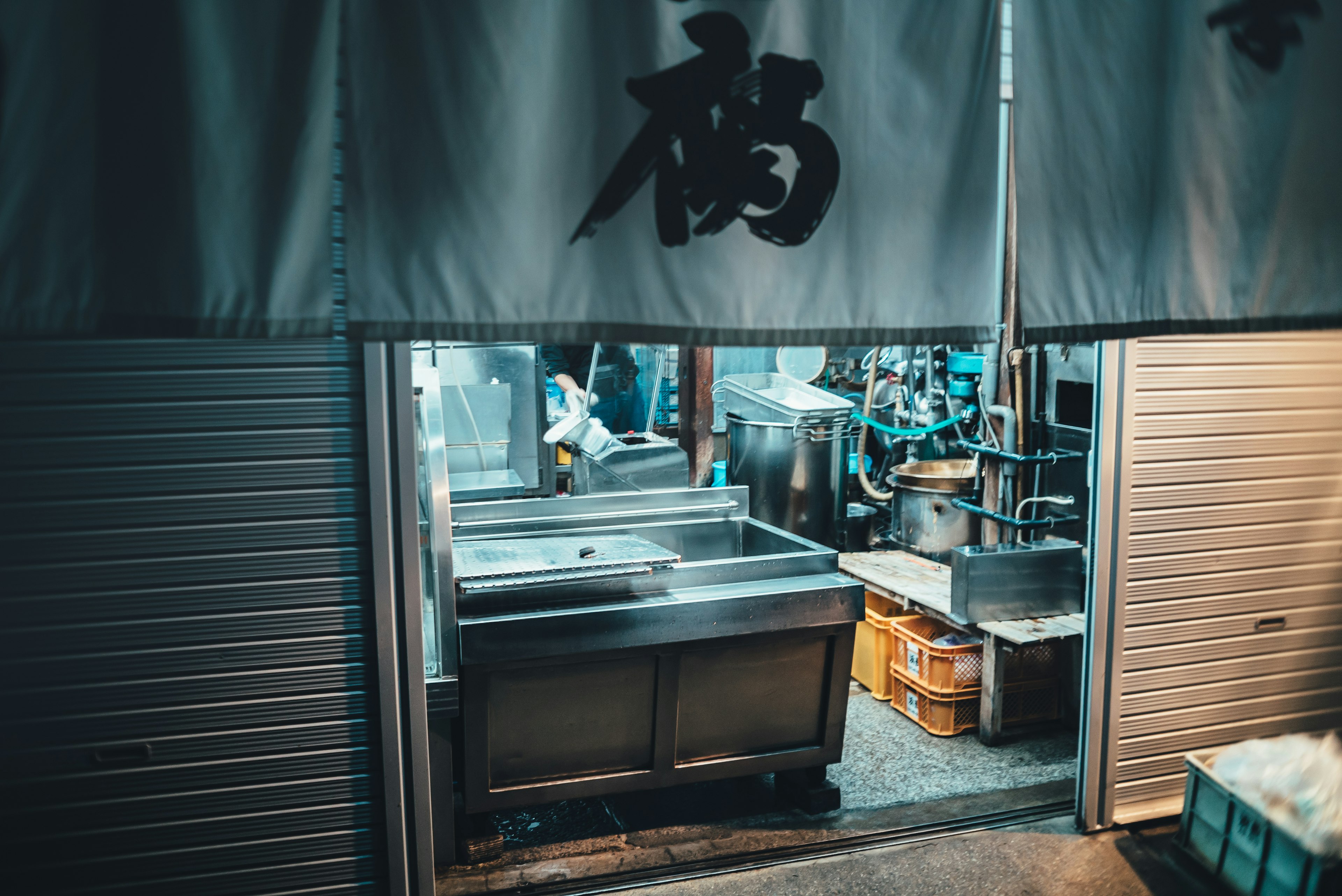 Vista nocturna de una cocina de restaurante visible a través de una cortina con el carácter de prosperidad