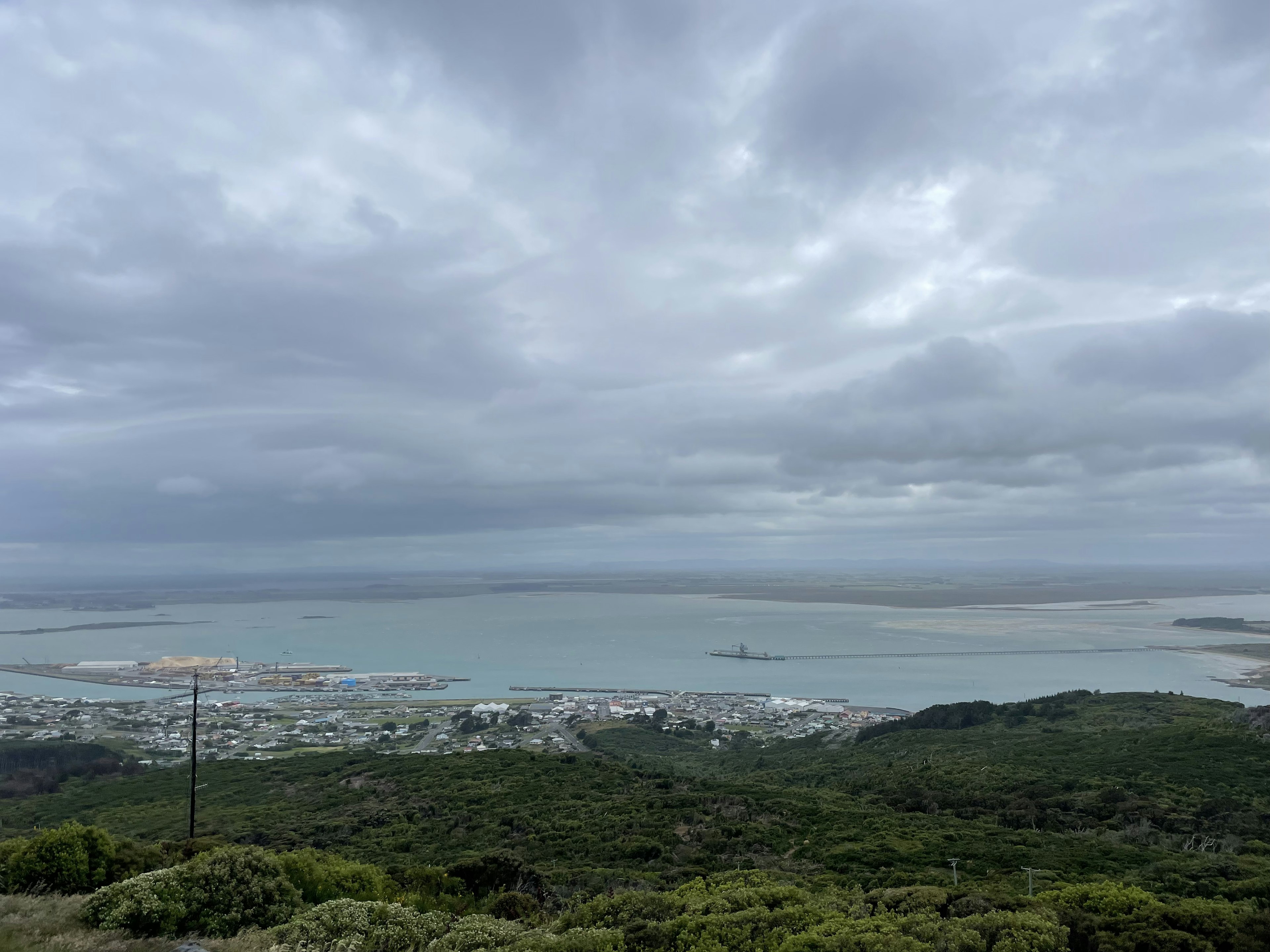 多雲的天空下的海岸景觀 綠色山丘和海洋