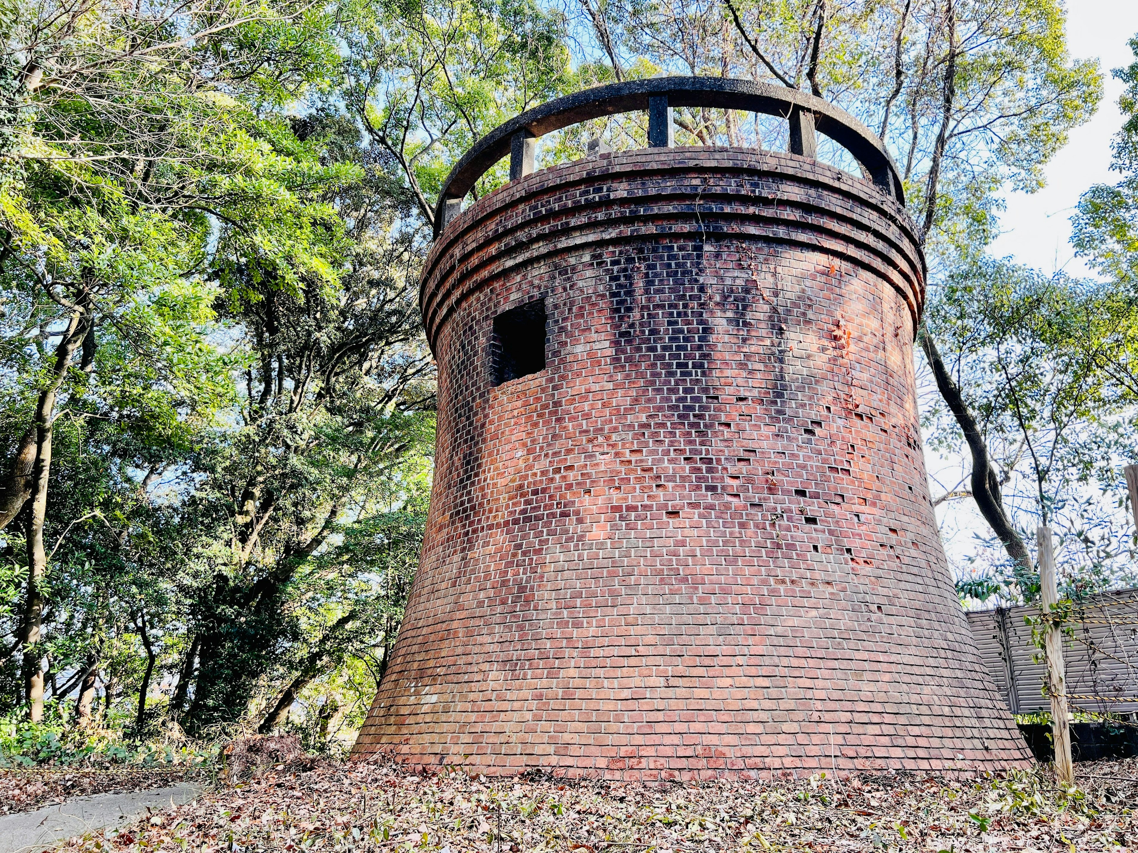 An old brick tower standing in a forest