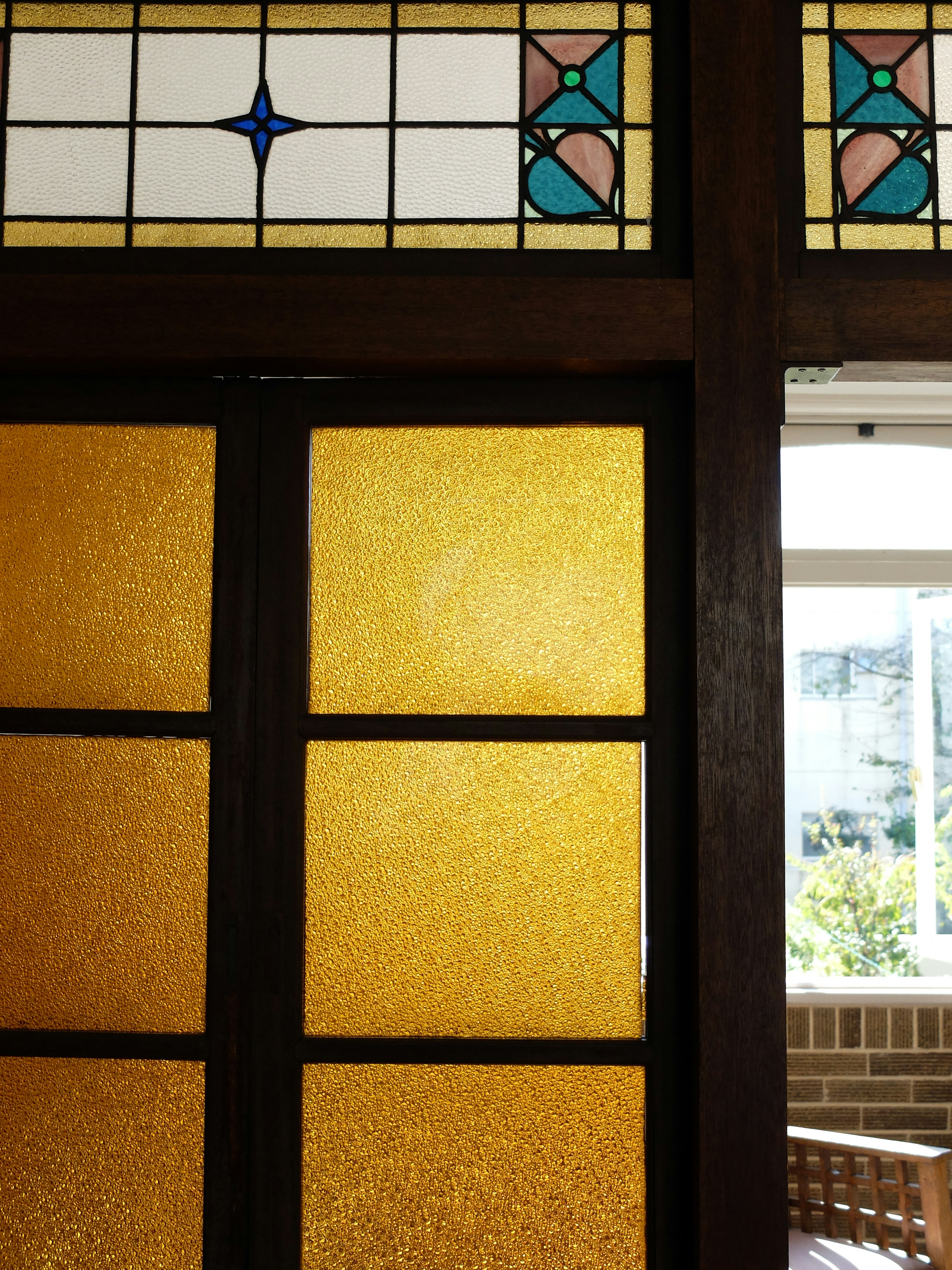 Wooden door with colorful stained glass window featuring geometric patterns