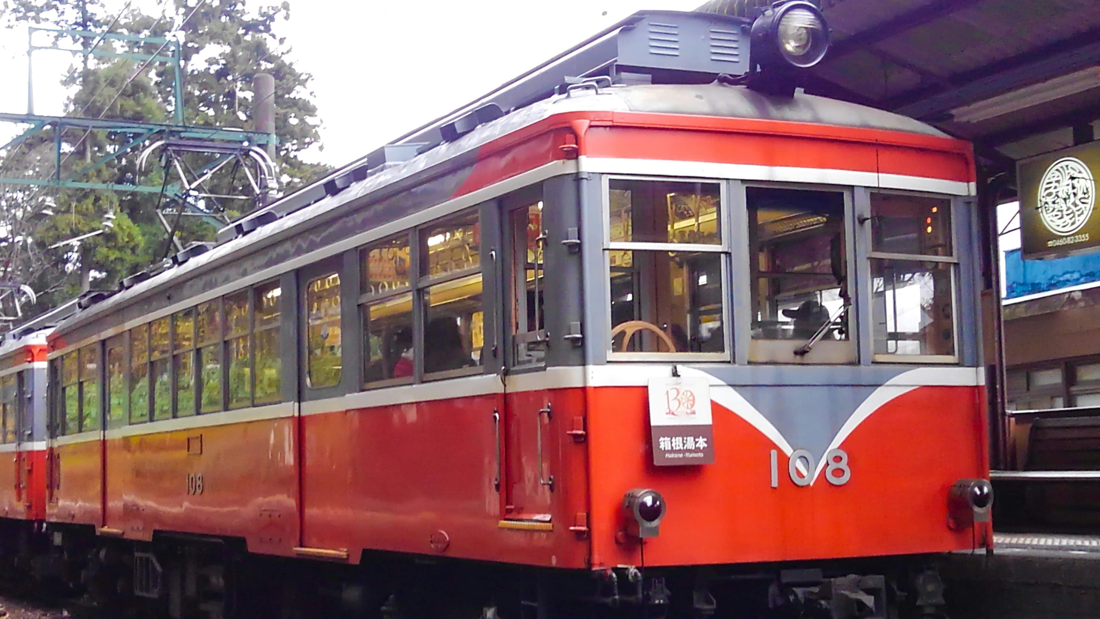 Red train at a station with vintage design