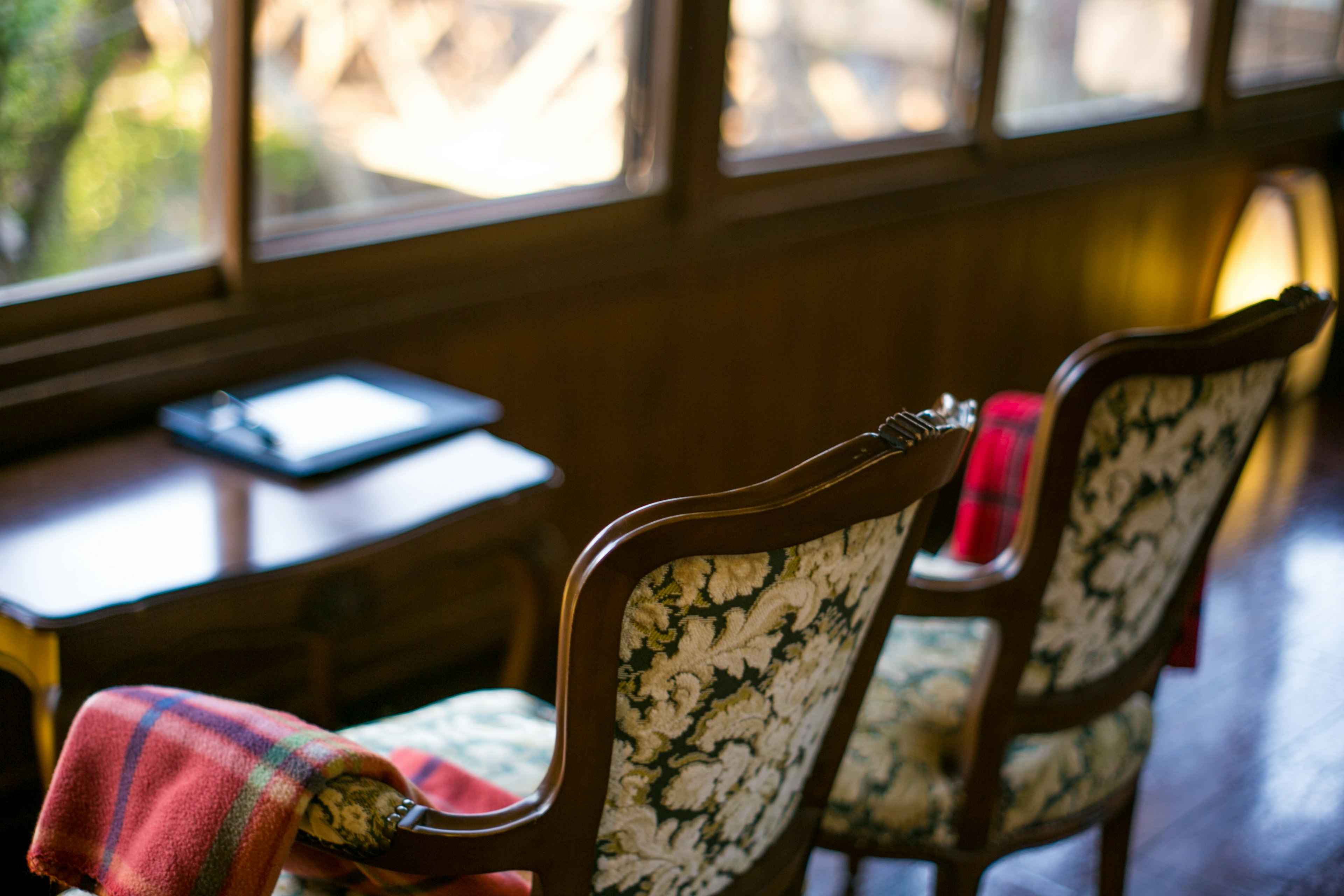 Two chairs by the window with a tablet on the table