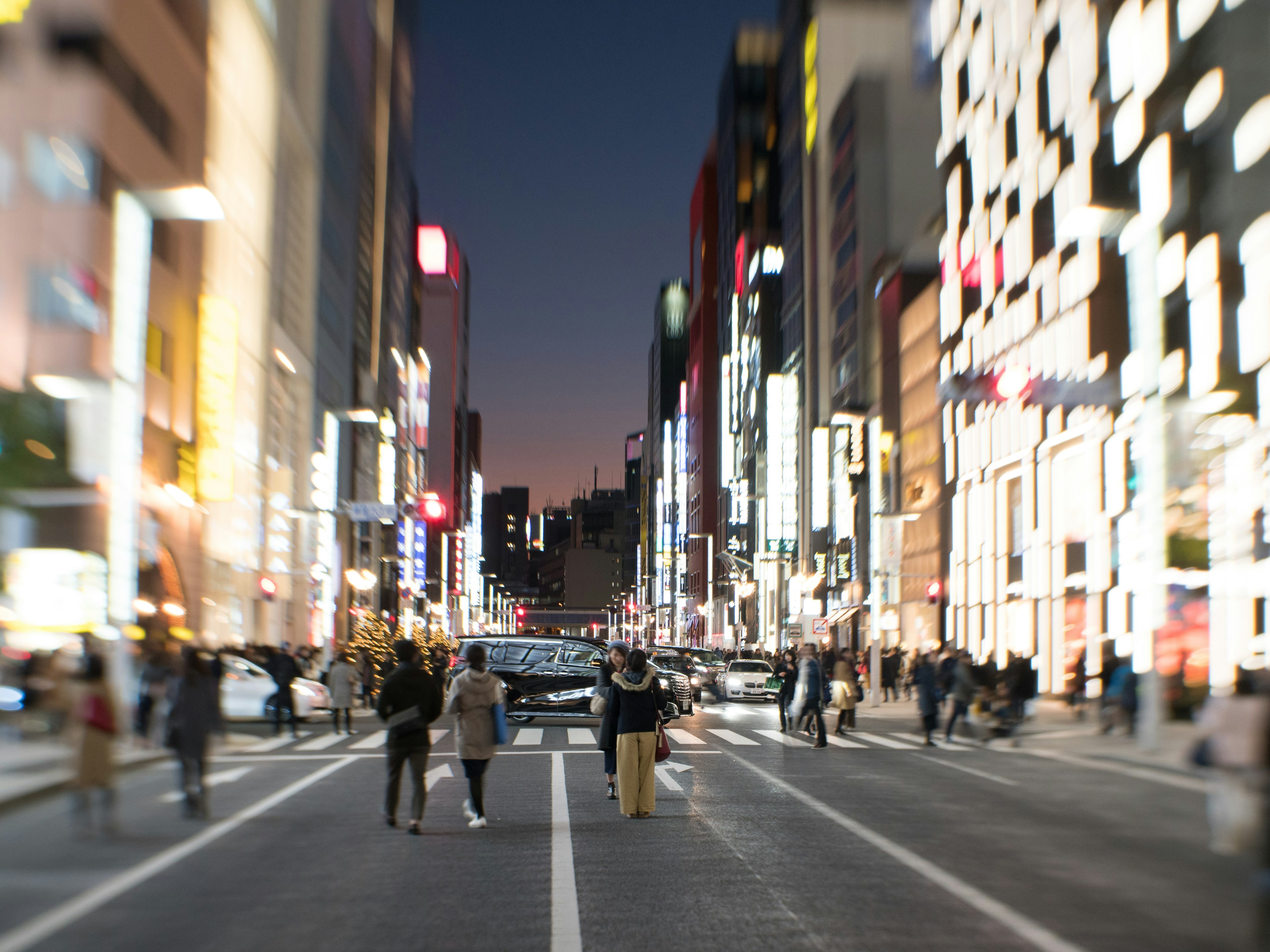 Blurred city street at night with people walking