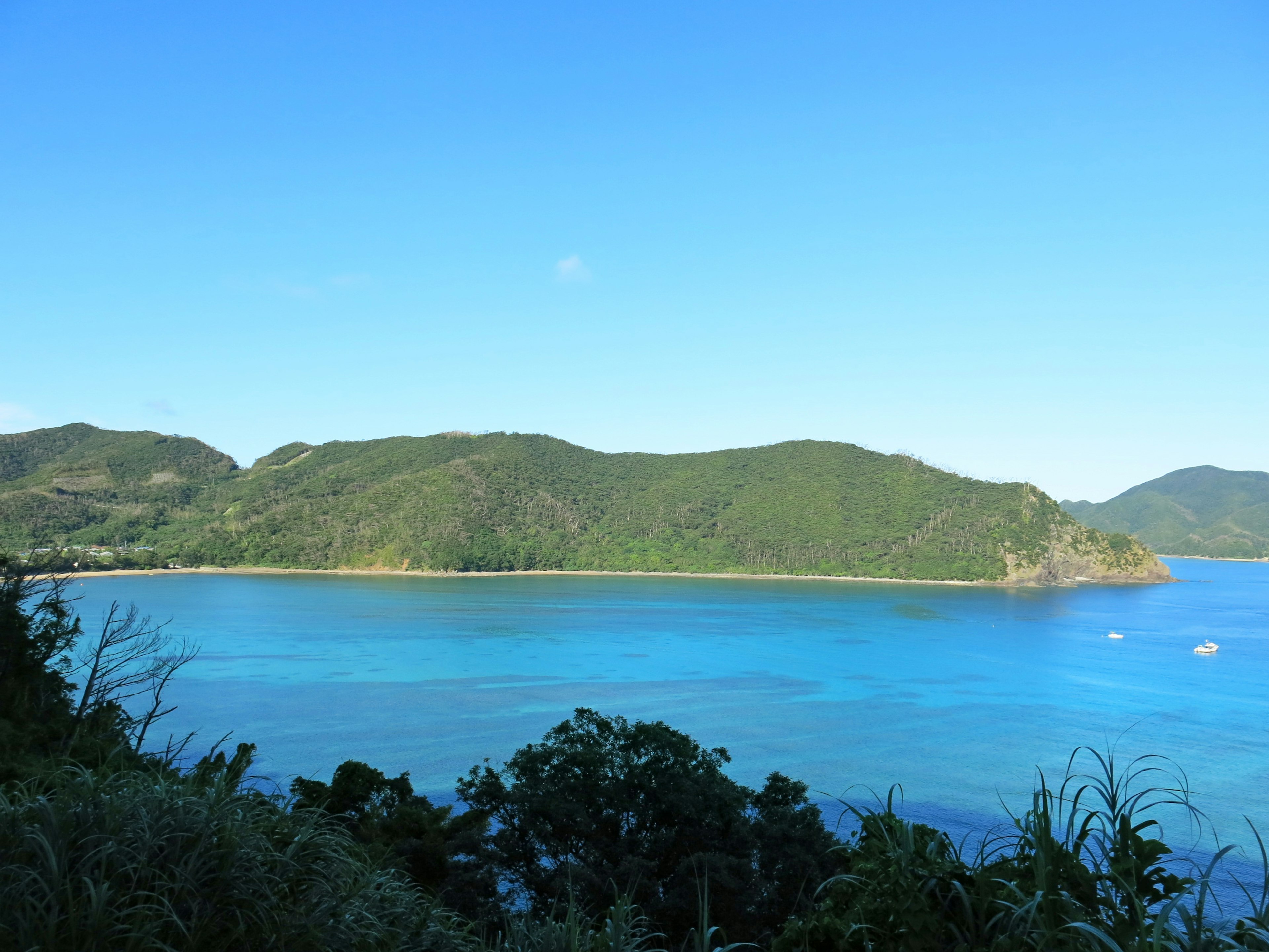 Scenic view of turquoise sea and green hills