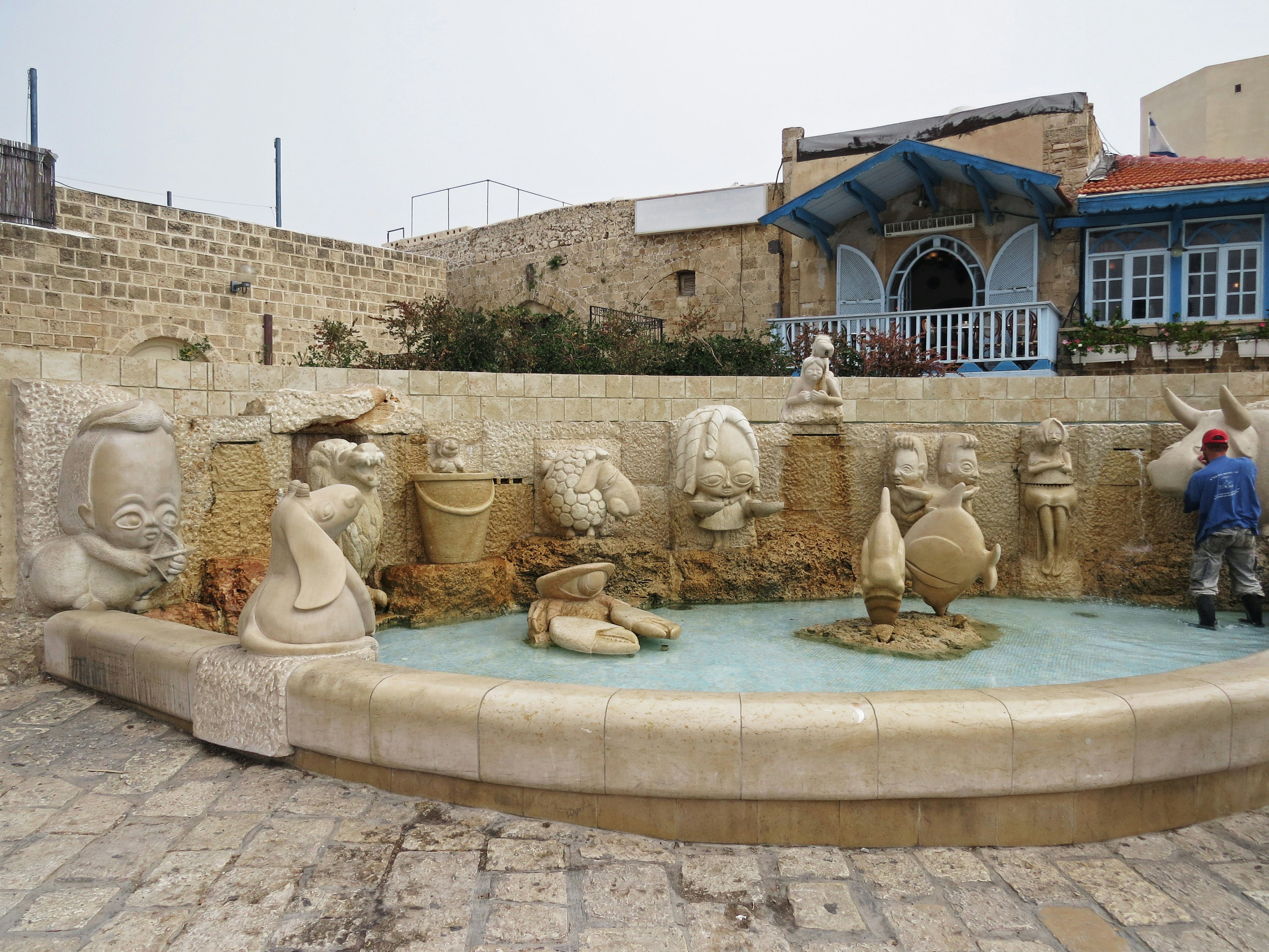 Paesaggio di una fontana con sculture che presentano acqua edificio tradizionale sullo sfondo