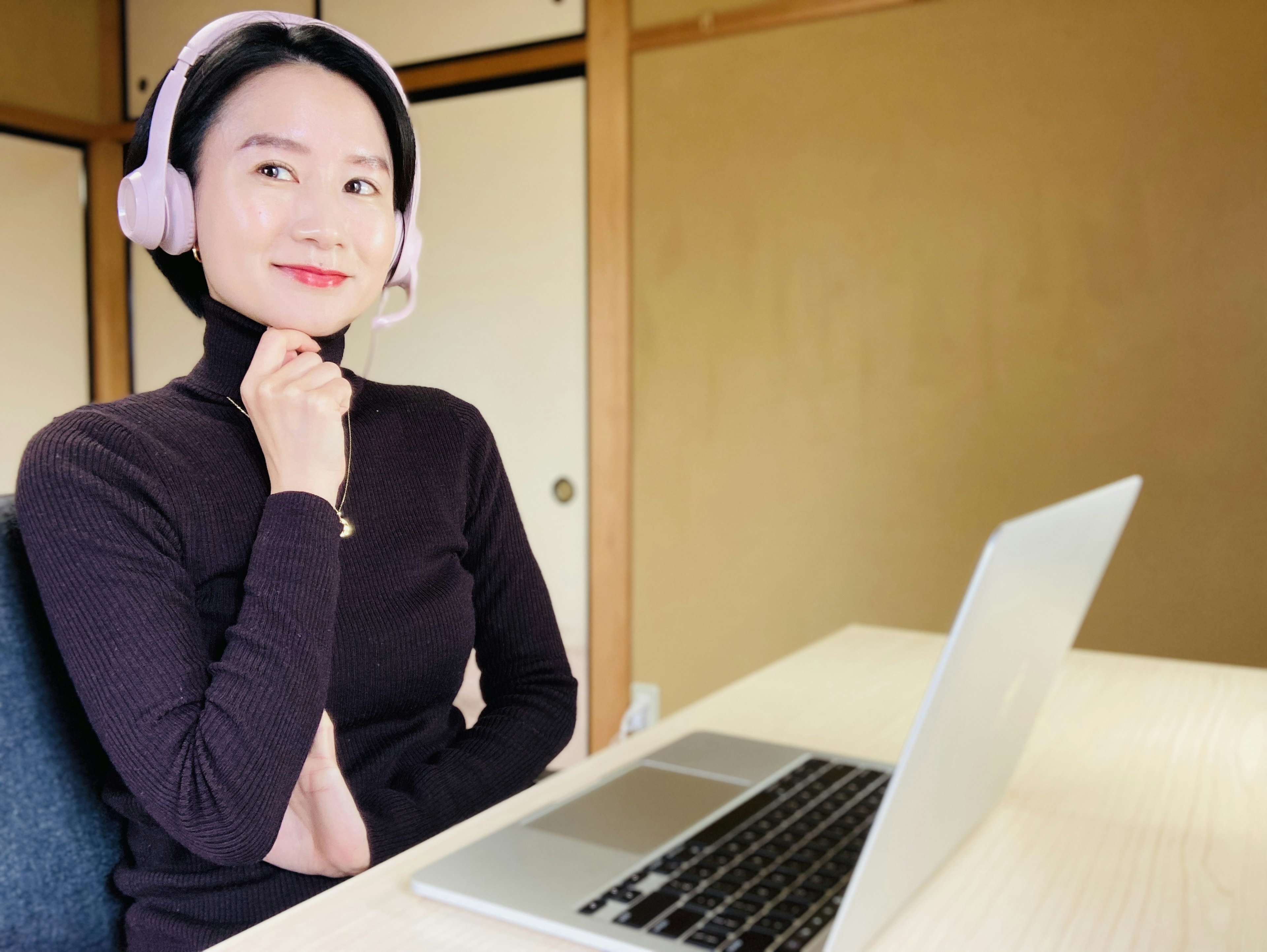 A woman wearing a headset sitting in front of a laptop