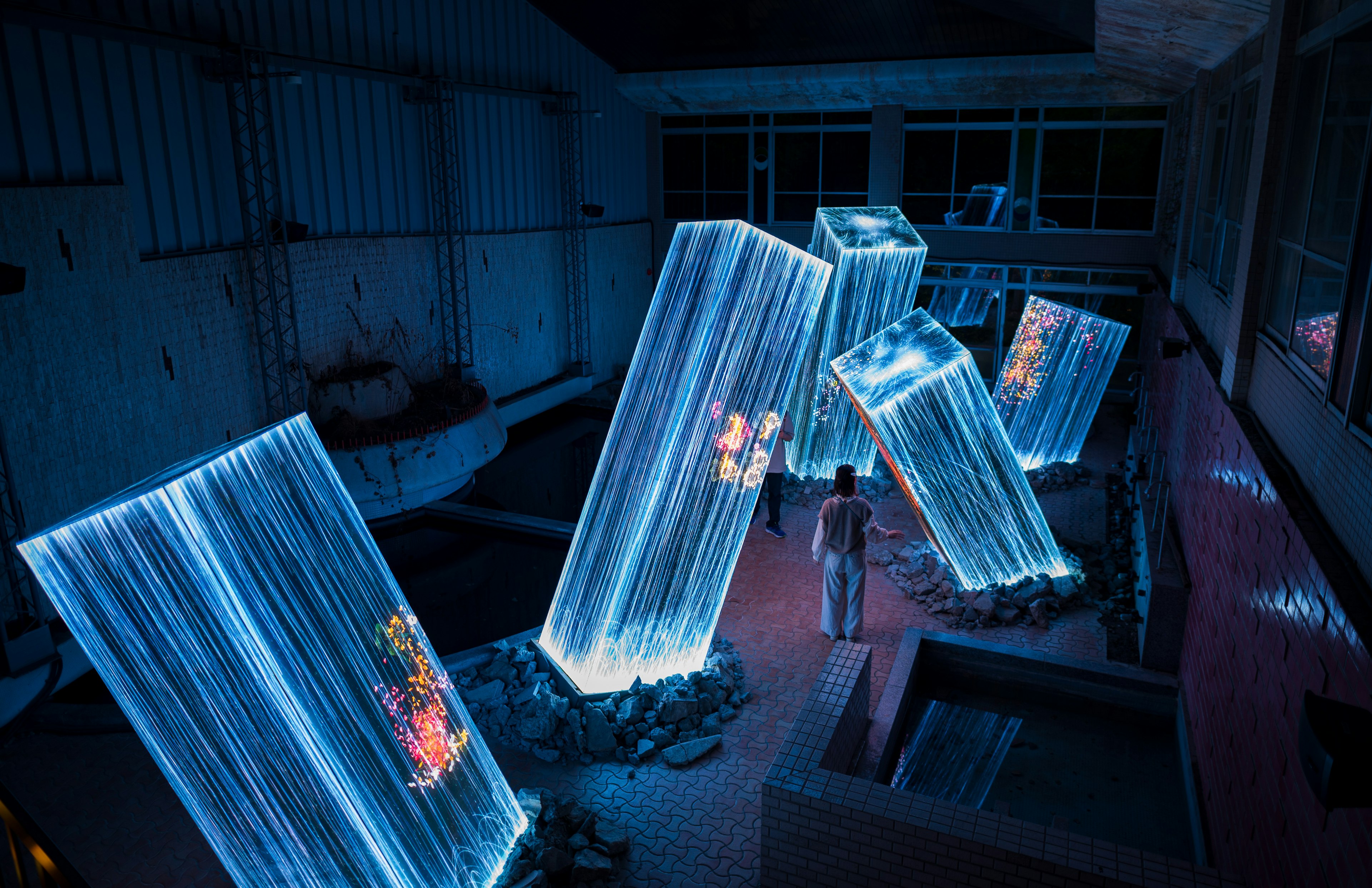 Una persona de pie en un espacio tenuemente iluminado con cubos transparentes brillantes