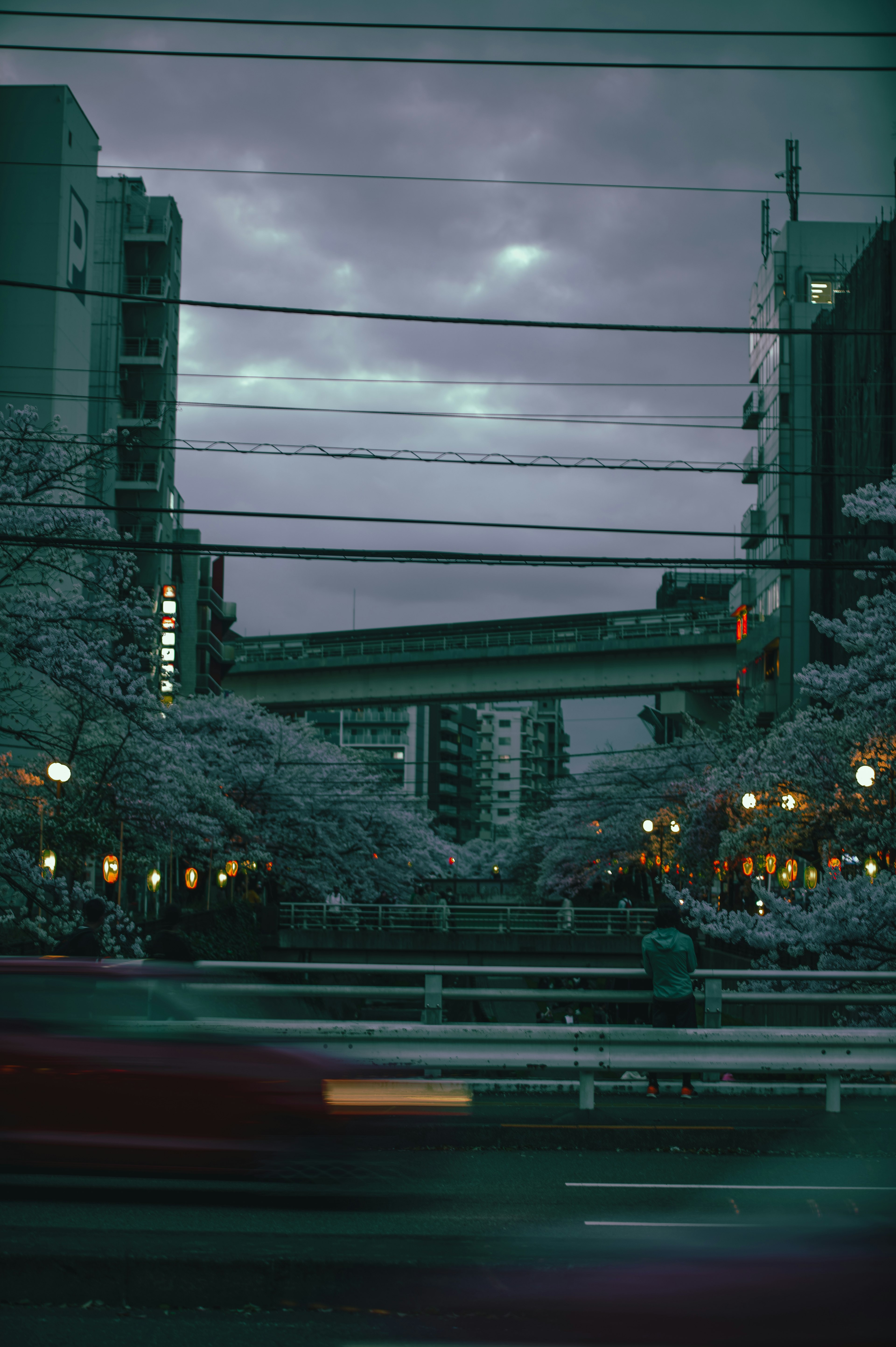 Urban landscape at dusk featuring elevated train tracks and street scene