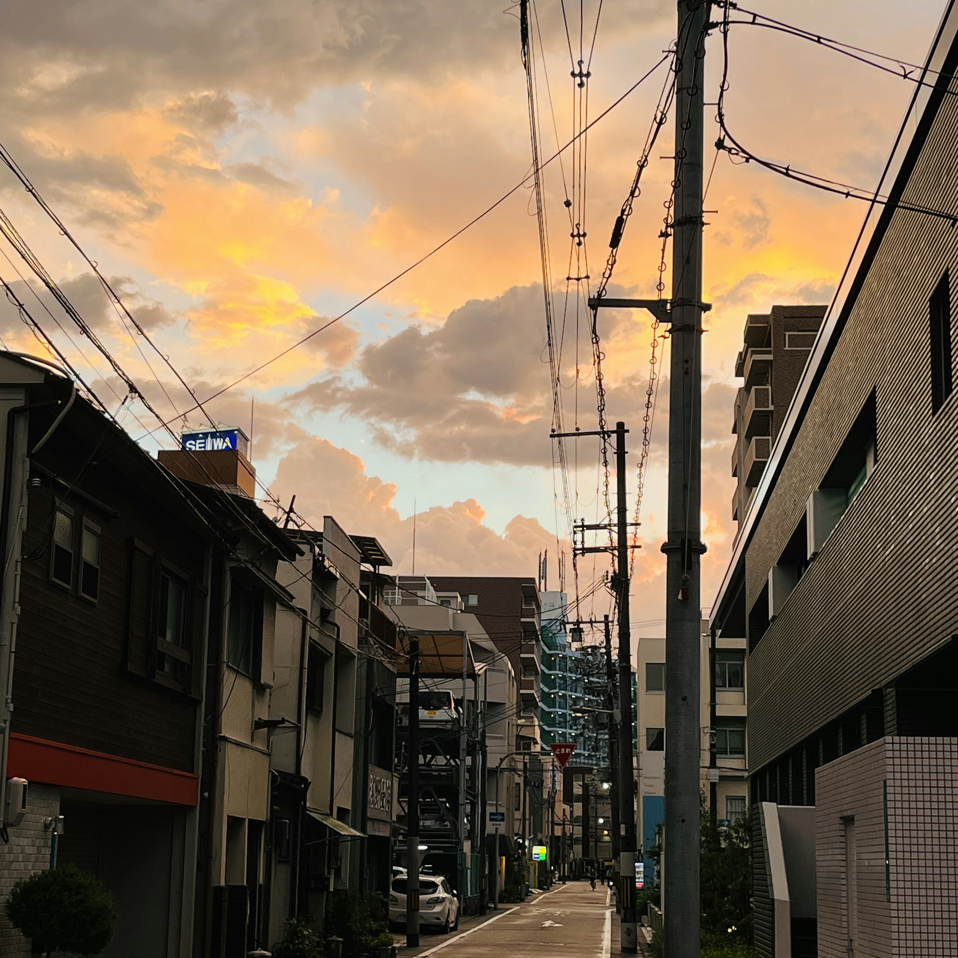 街景展示了夕阳西下的天空和多彩的云朵旧建筑和现代建筑沿着狭窄的道路