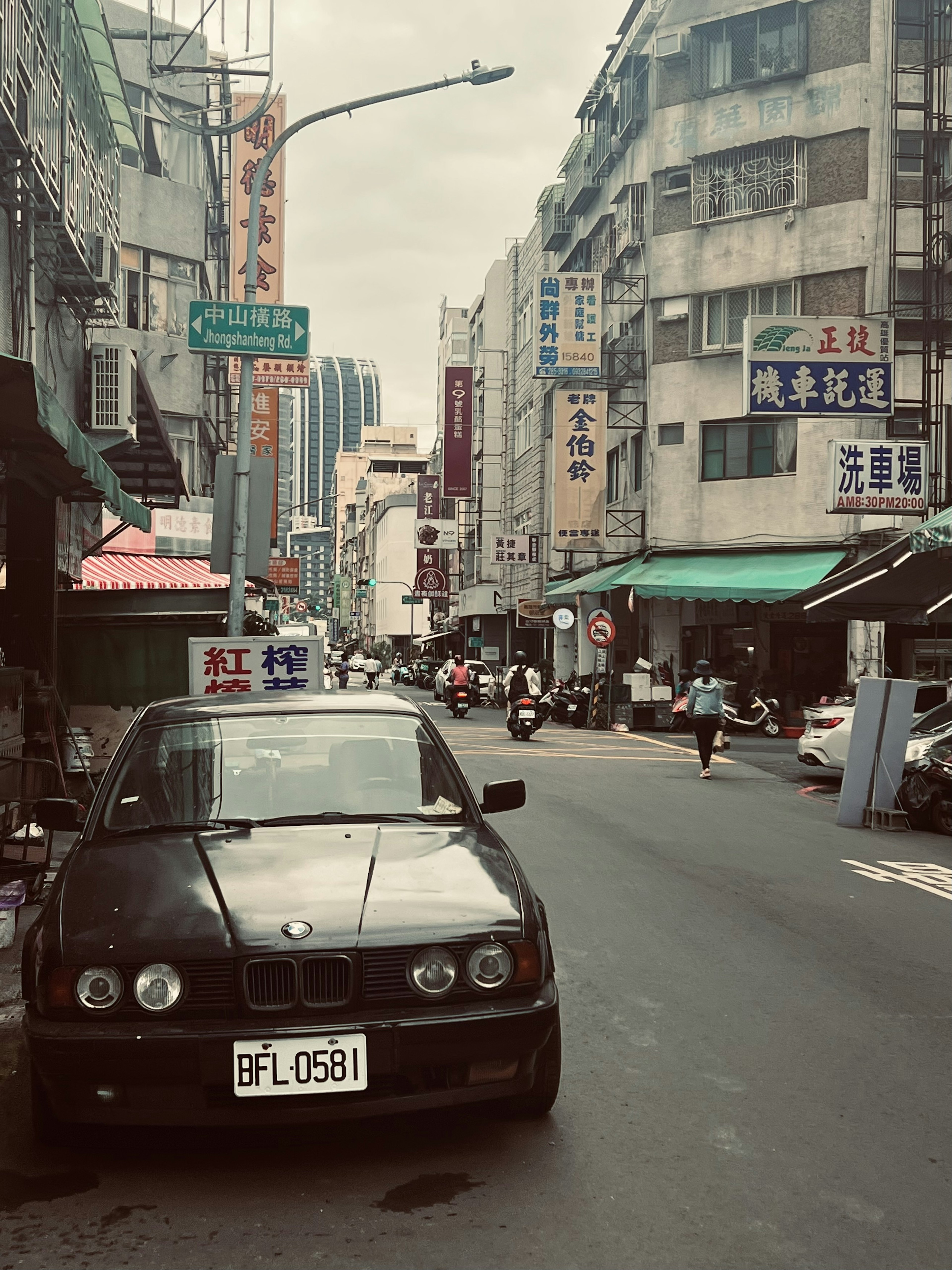 街の通りに停まっている黒い車と周囲の建物