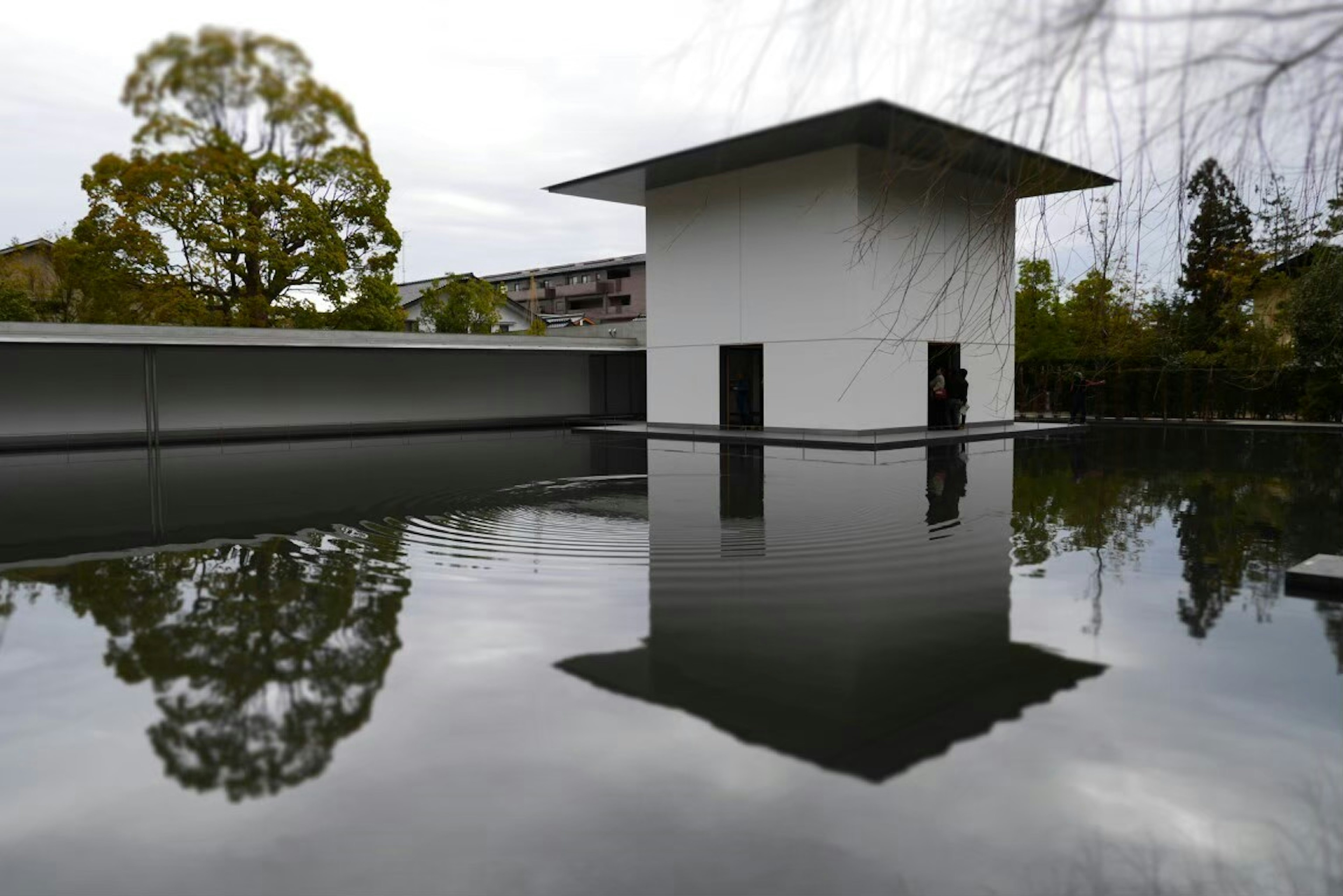 A white building reflecting on a calm water surface